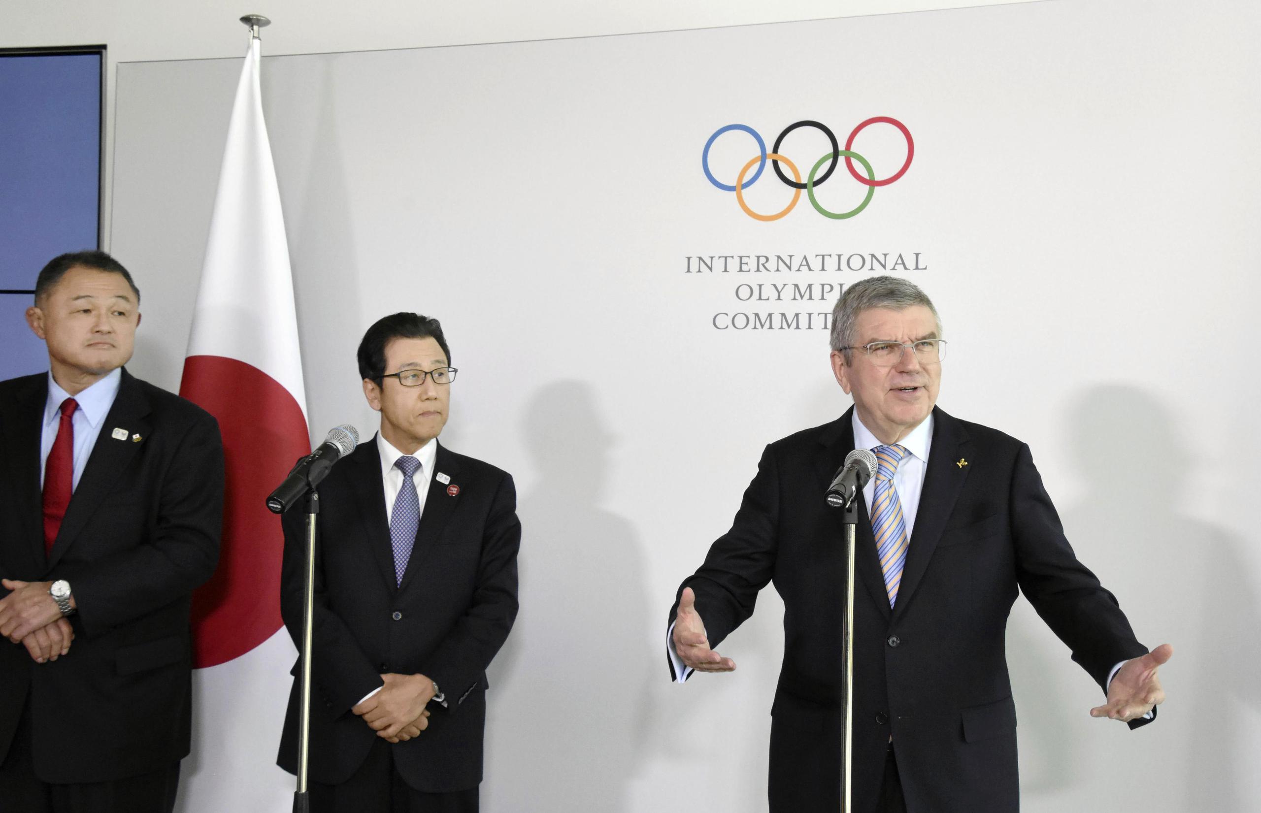 El presidente del Comité Olímpicos de Japón, Yasuhiro Yamashita, y el alcalde de Sapporo, Katsuhiro Akimoto, escuchan al presidente del COI, Thomas Bach, durante una conferencia de prensa en Lausana, Suiza el 11 de enero del 2020.