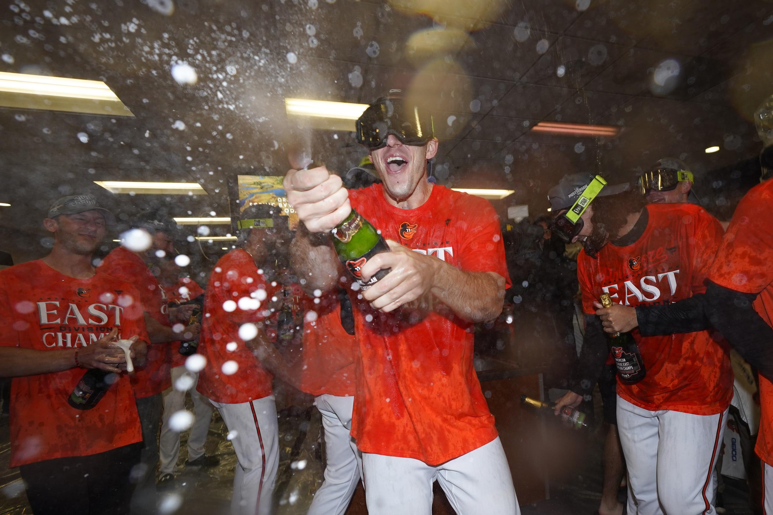 El lanzador de los Orioles de Baltimore, John Means, (centro) celebra junto a su equipo la conquista del campeonato.