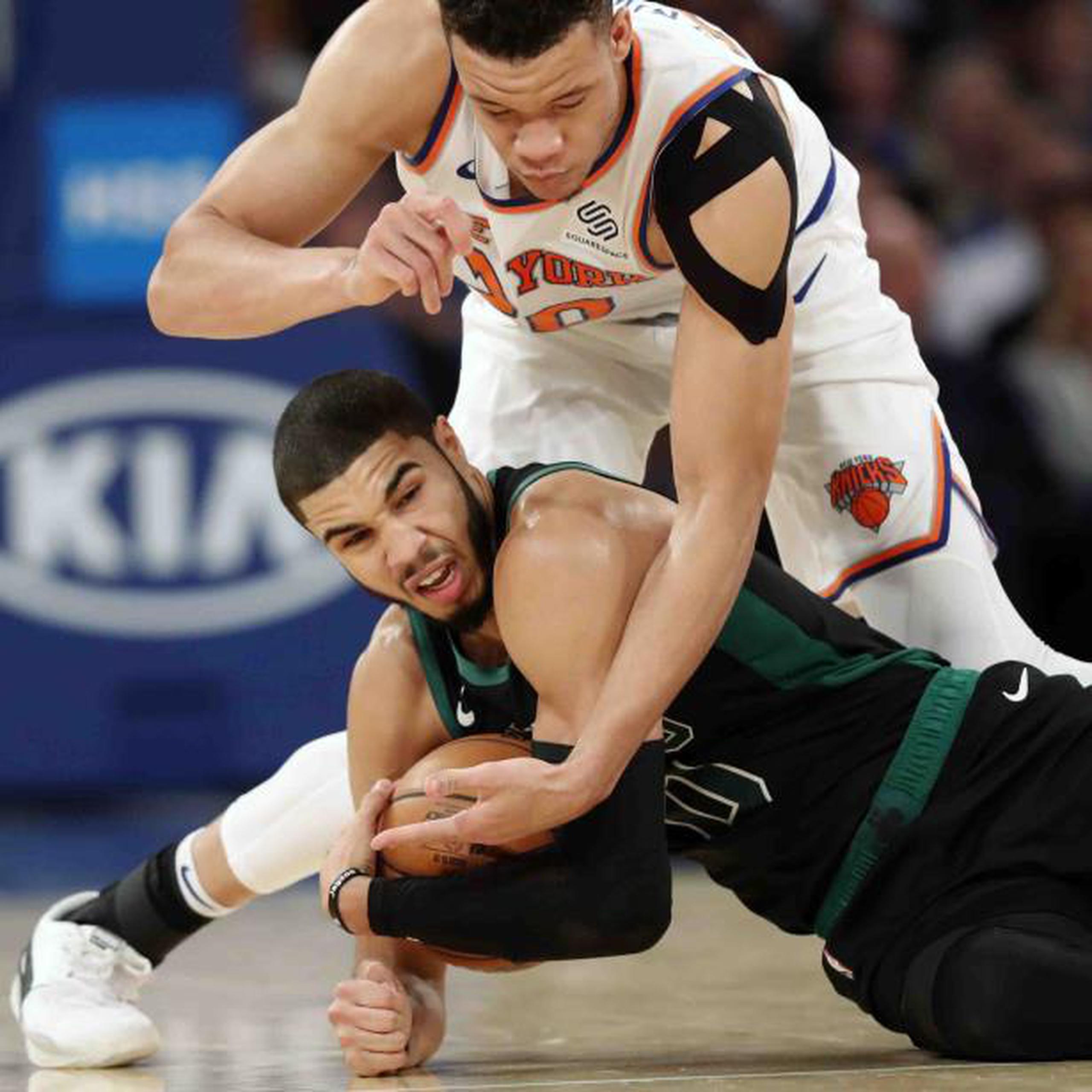 Jayson Tatum de los Celtics, protege el balón ante la defensa de Kevin Knox de los Knicks. (AP)