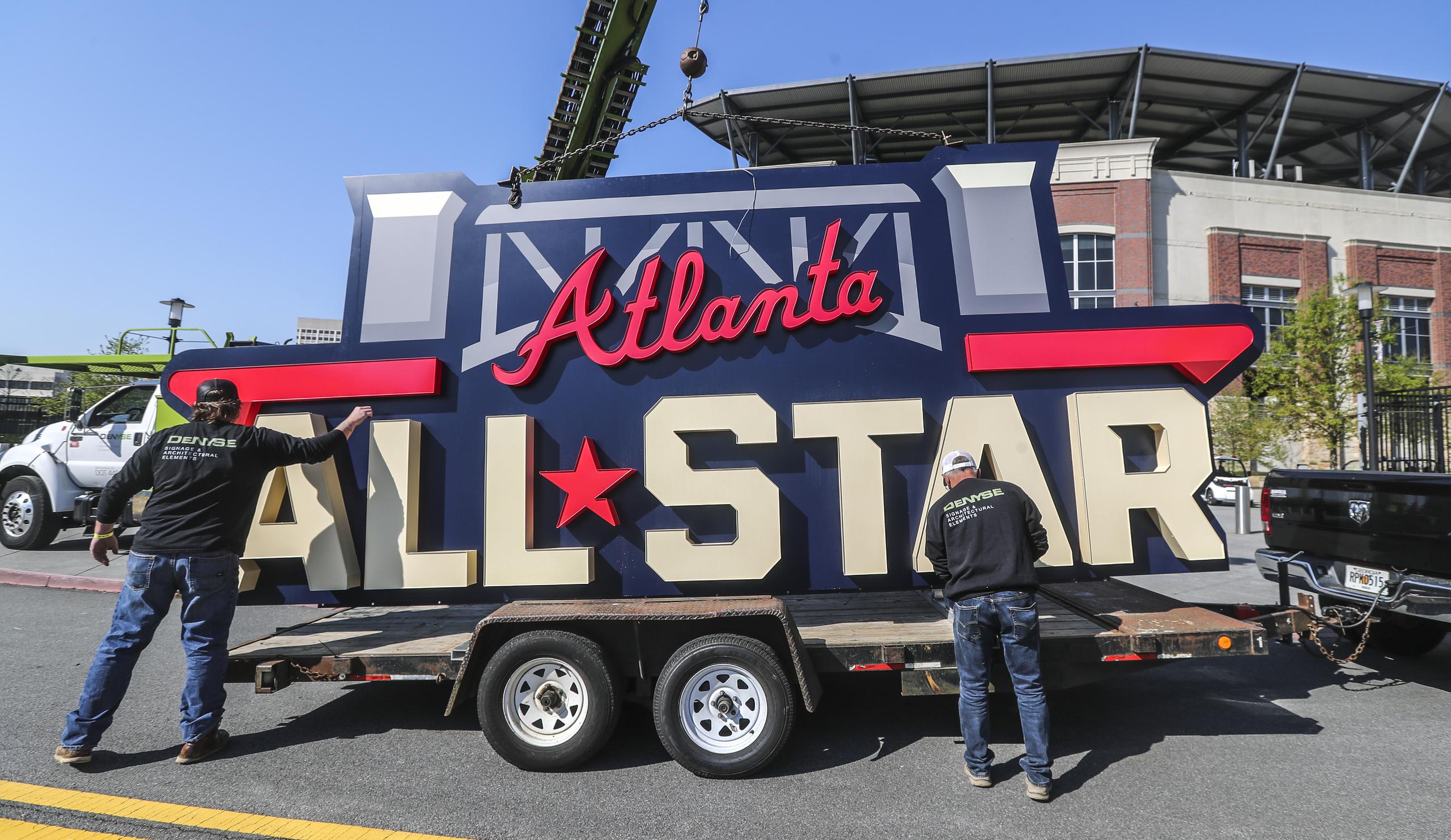 Trabajadores cargan un letrero del Juego de Estrellas en un remolque después de que fuera retirado del Truist Park de Atlanta.