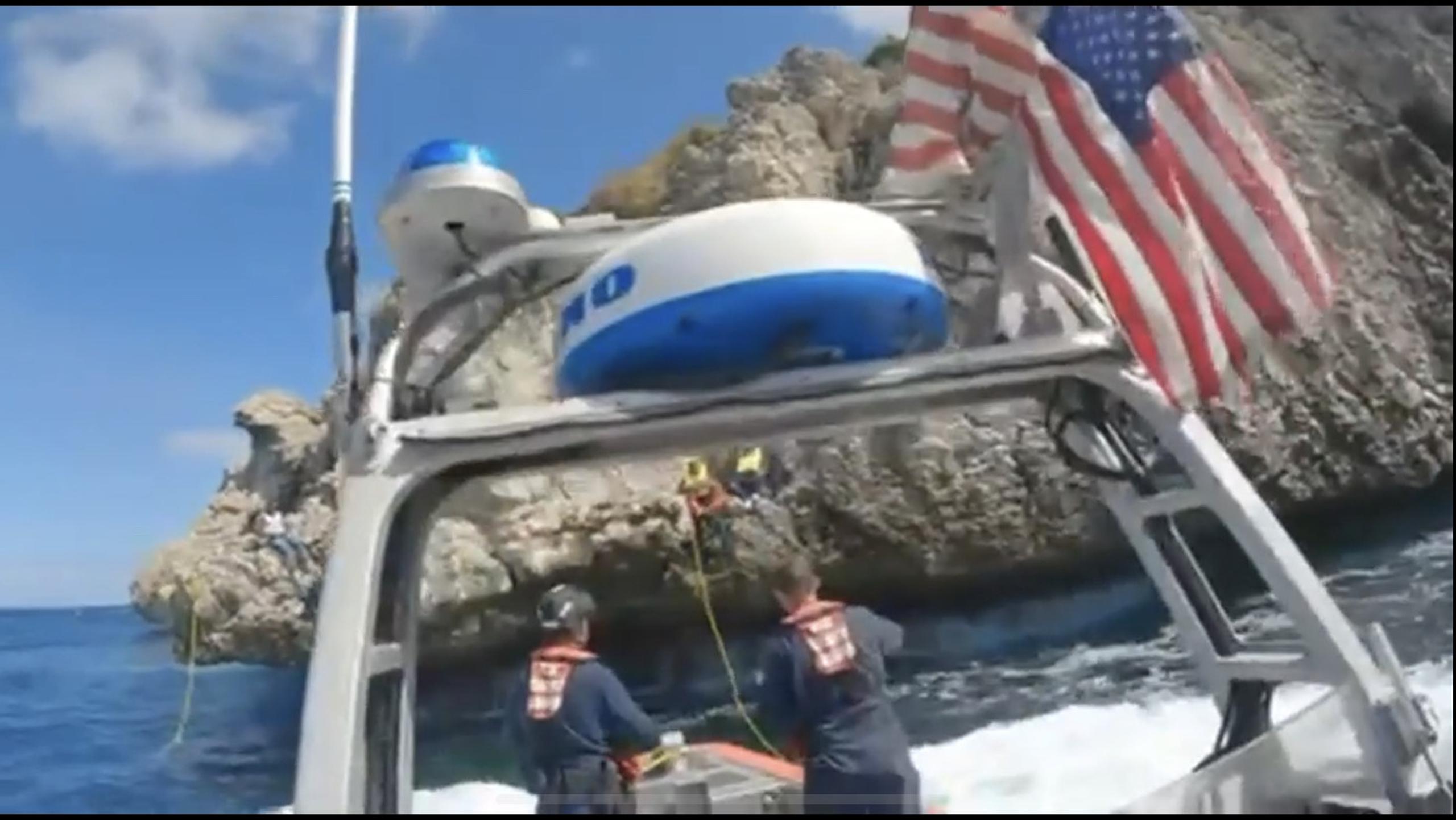 Los migrantes saltaron de uno en uno a un salvavidas que la tripulación del bote usó para recuperarlos del agua de manera segura.