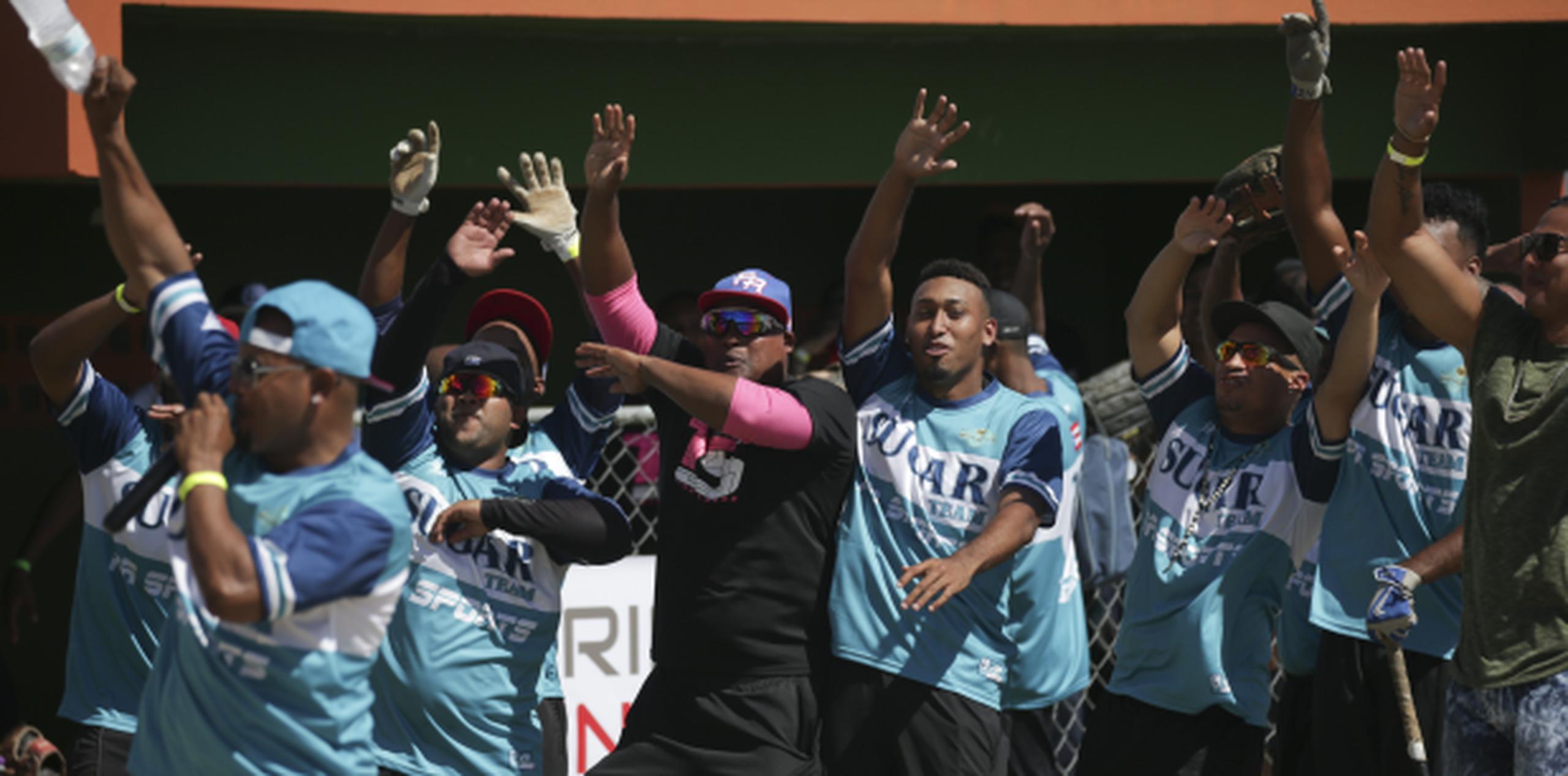 Uno de los anfitriones del Sugar vs. Machete Softball Game, Edwin Díaz, al centro, celebra un momento del evento efectuado ayer en Naguabo. (teresa.canino@gfrmedia.com)