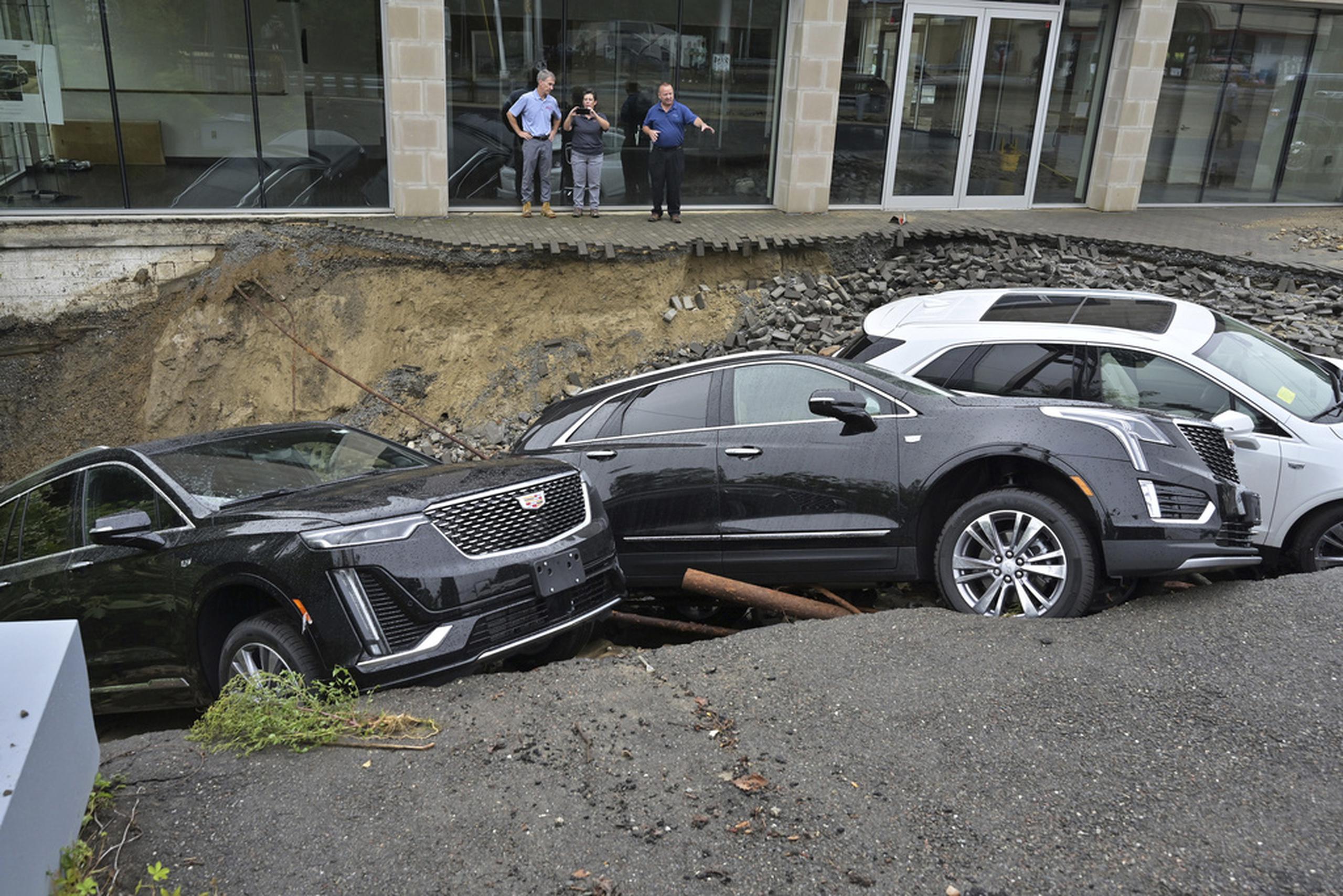Tres vehículos cayeron en un sumidero en los predios de un concesionario de autos el martes en Leominster, Massachusetts.