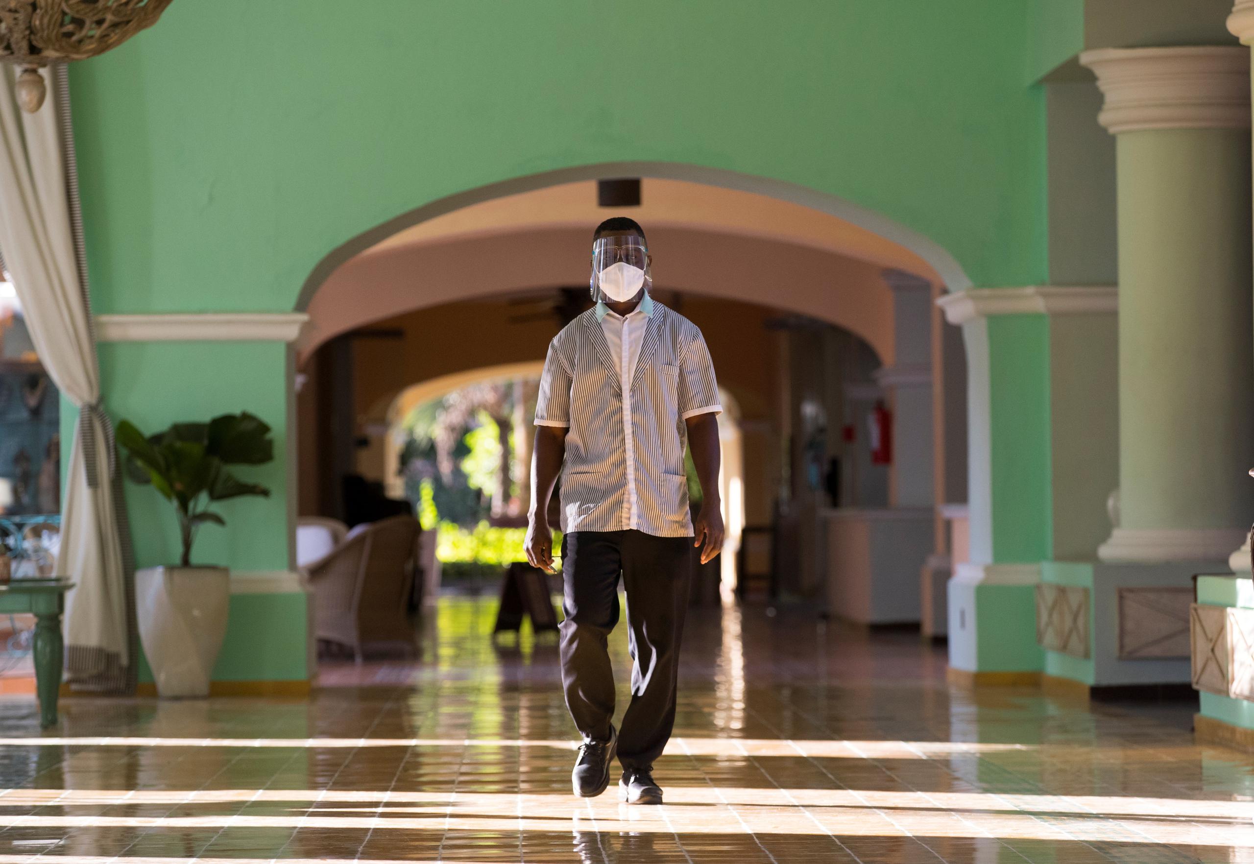 Un empleado utiliza implementos de protección mientras camina durante la reapertura del hotel Iberostar Selection Hacienda Dominicus, hoy en Bayahibe, República Dominicana.