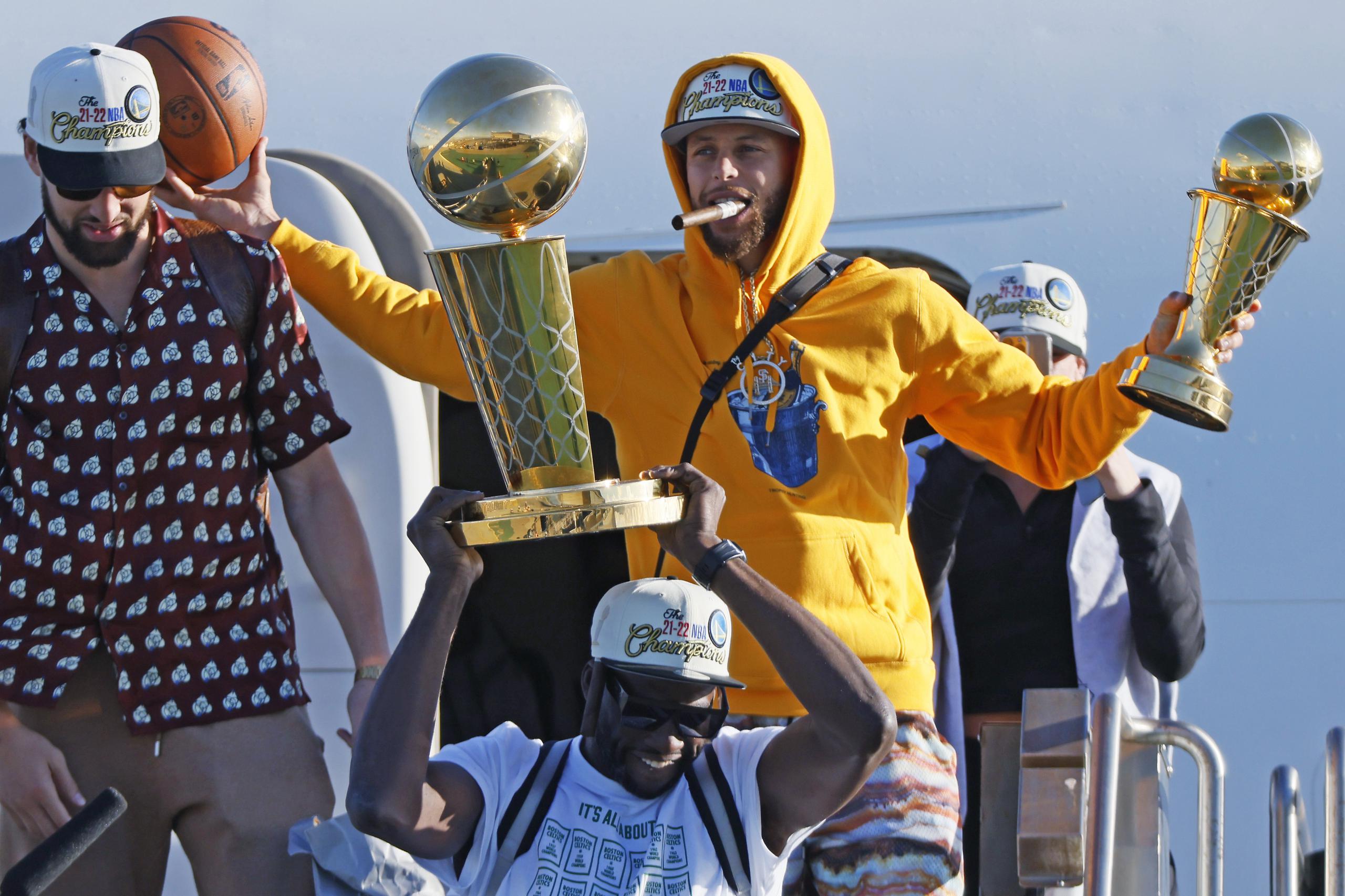 Los Warriors de Golden State, incluido Stephen Curry, sosteniendo su trofeo como el Más Valioso de la final de la NBA, arribaron ayer al aeropuerto de San Francisco tras derrotar el jueves a los Celtics de Boston.