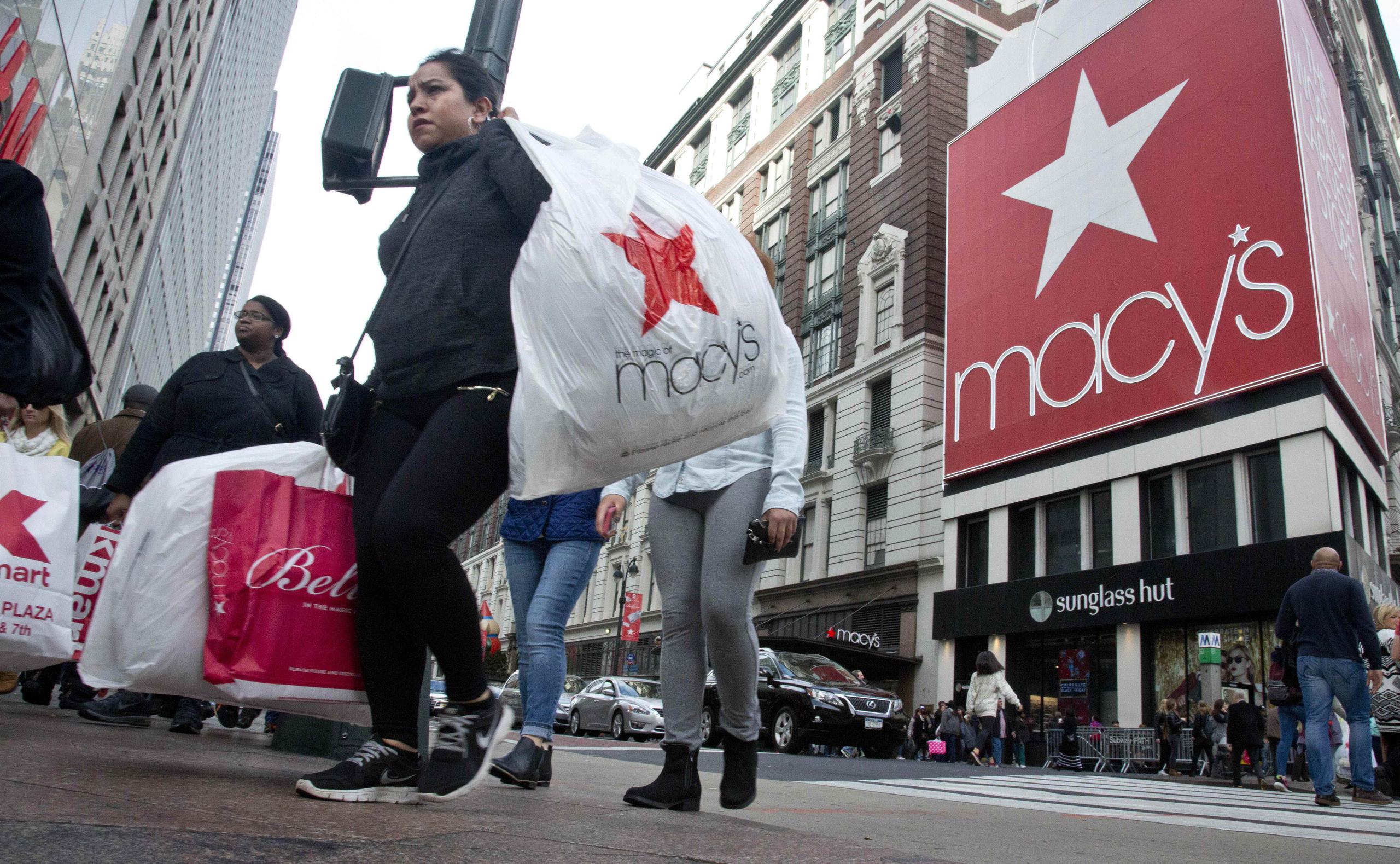 Clientes salen de la tienda de Macy's, en Herald Square, Nueva York. La ropa y calzado invernal son de los productos más afectados. (AP)