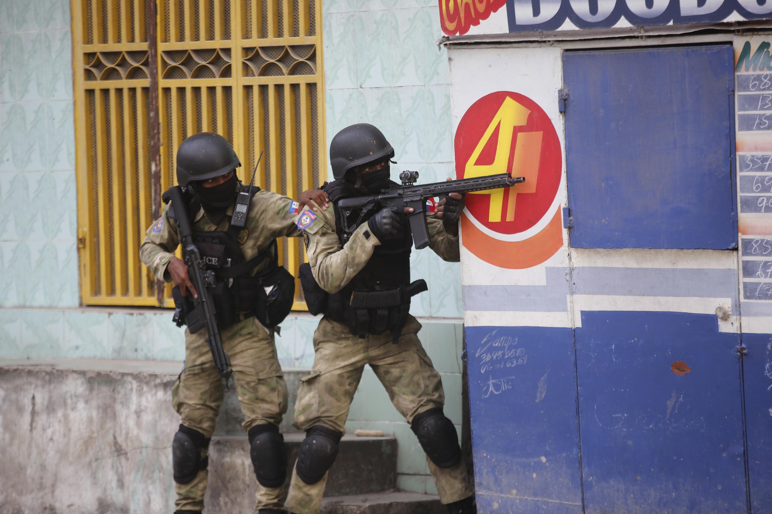 Policías se resguardan durante un operativo antipandillas en el vecindario Portail el jueves 29 de febrero de 2024, en Puerto Príncipe, Haití. (AP Foto/Odelyn Joseph)