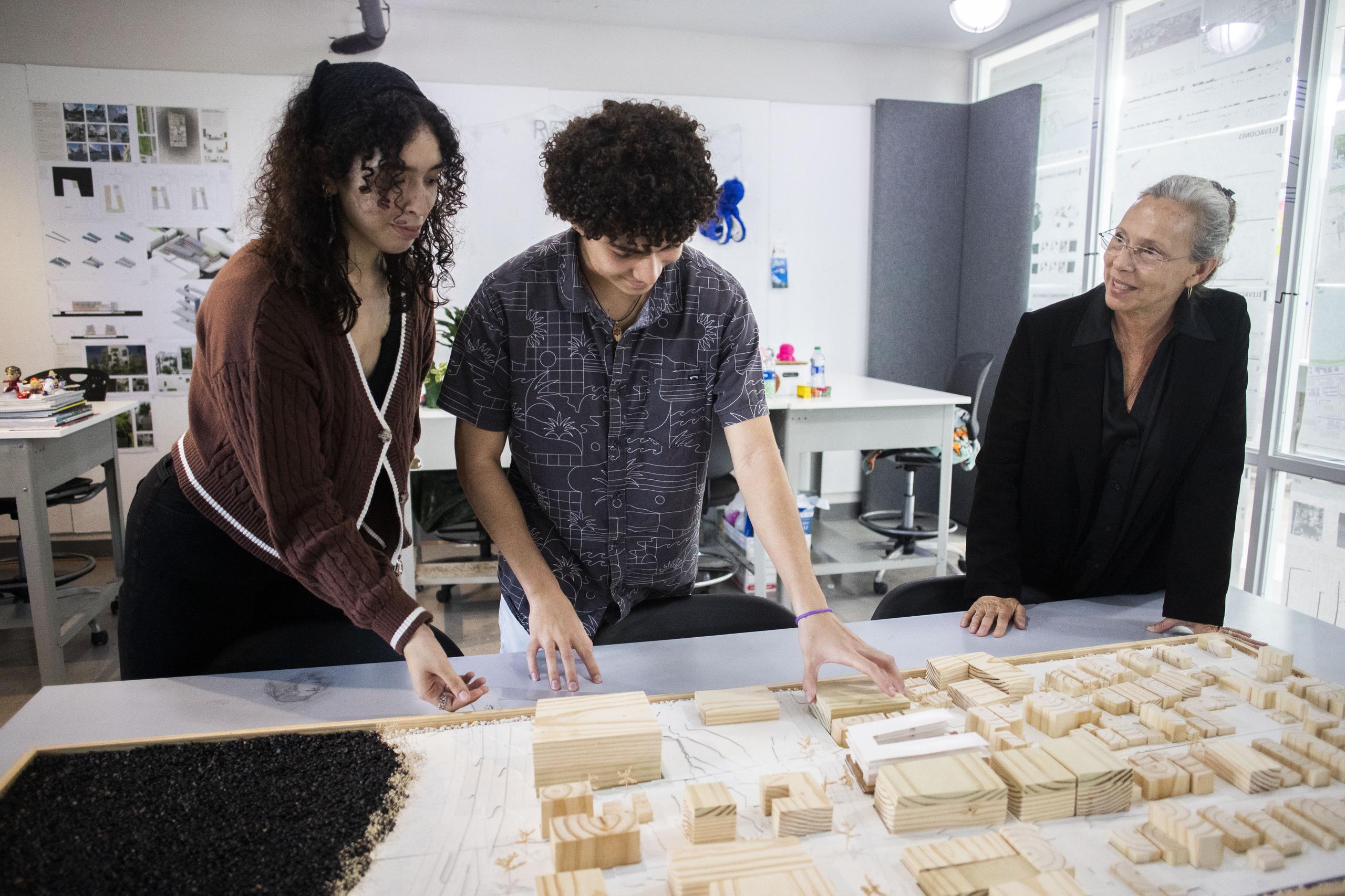 La decana interina de la Escuela de Arquitectura de la UPR, Anna Georas Santos, junto a dos estudiantes en su taller de la institución.