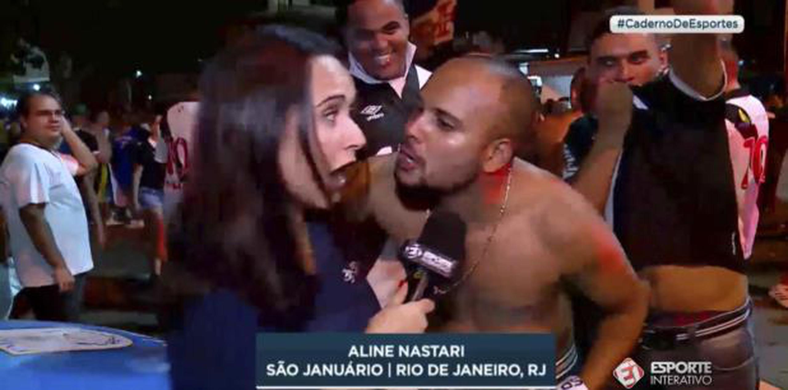 Un hombre trata de besar a la reportera deportiva Aline Nastari durante una transmisión de un partido de fútbol en el estadio Sao Juanario en Río de Janeiro. (AP)