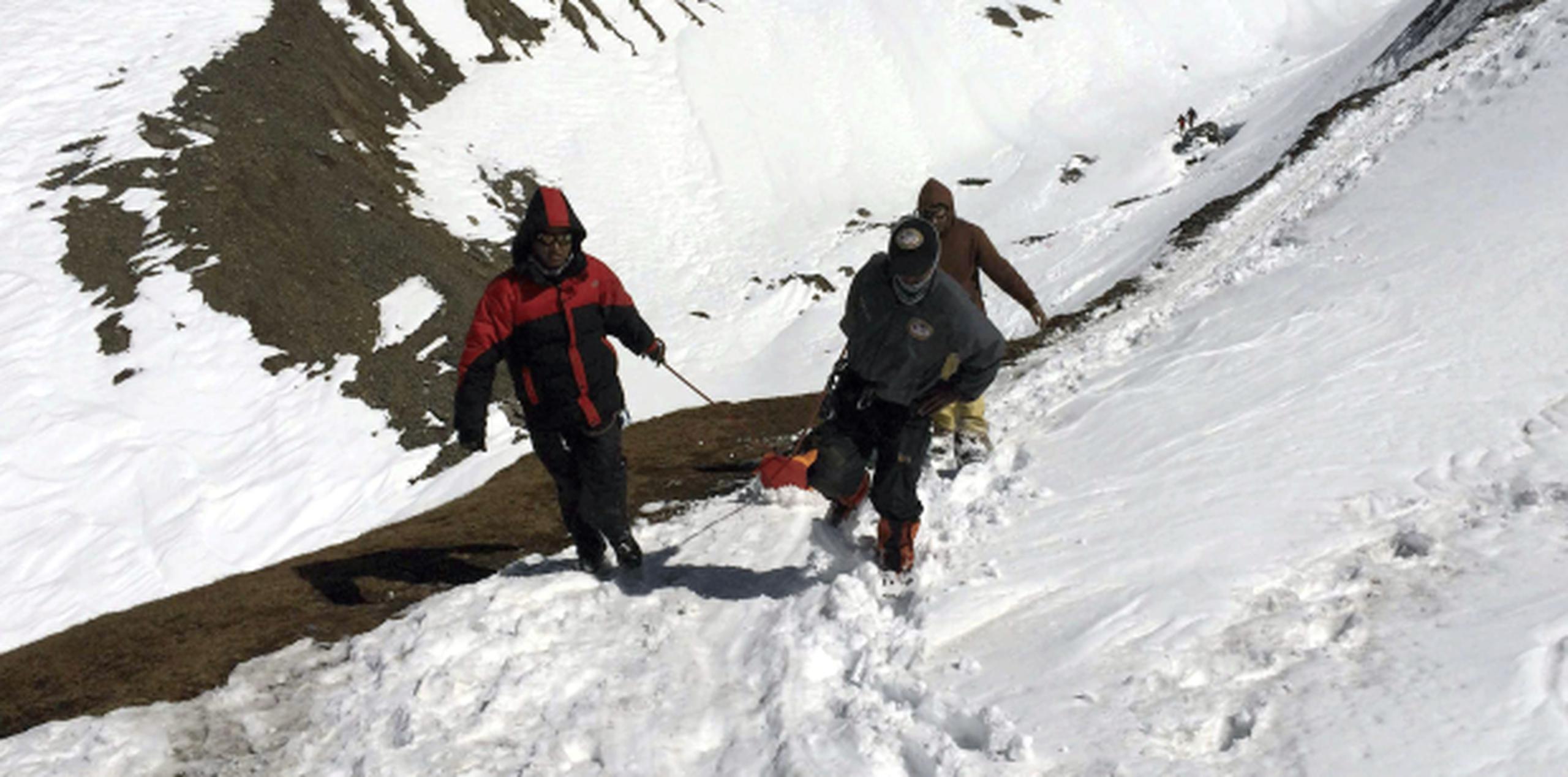 En la foto, tres soldados que trasladan el cuerpo sin vida de un montañero en el paso Throung La del circuito de Annapurna. (EFE)