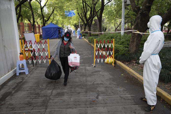 Una persona regresa a casa después de estar en cuarentena por casos de COVID-19 en Shanghái.