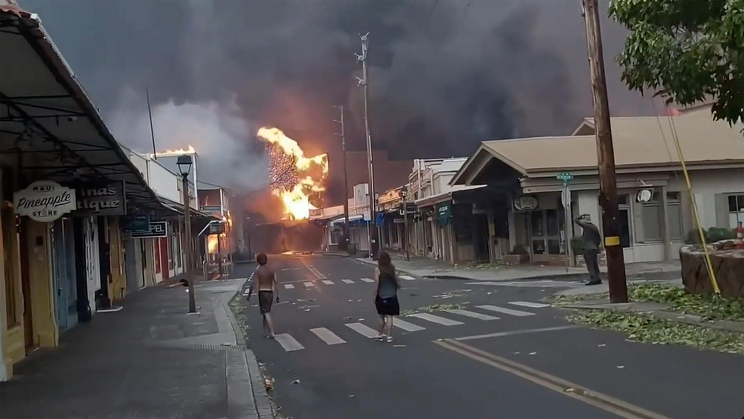 Varias personas observan mientras el humo y las llamas de los incendios forestales llegan a Front Street, en el centro de Lahaina, en Maui, Hawai, el 8 de agosto de 2023.