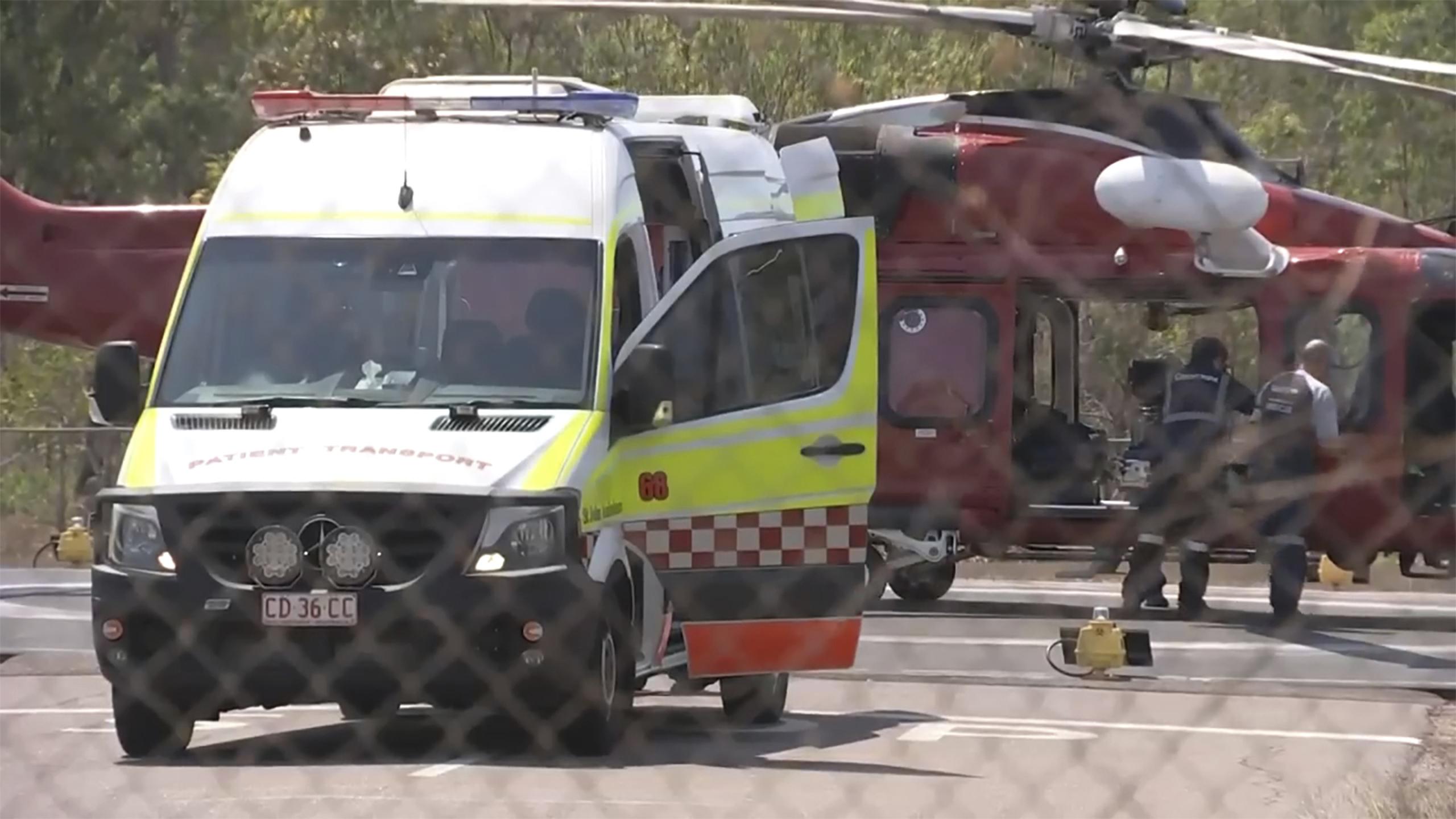 Esta imagen tomada de un video muestra a un helicóptero y a una ambulancia que participan en una misión de rescate tras el choque de un avión, el domingo 27 de agosto de 2023, en Darwin, Australia. (AuBC vía AP)