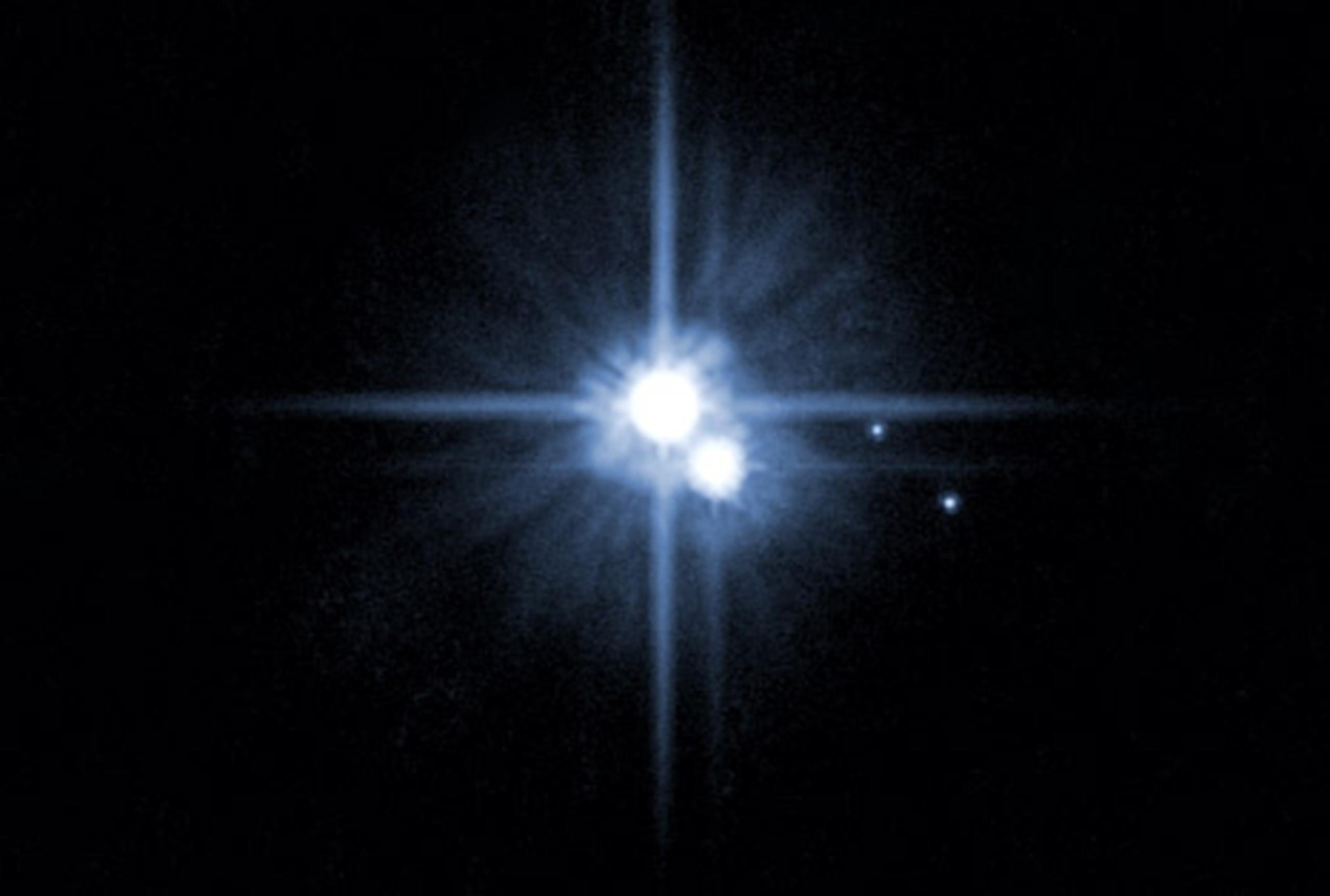 Imagen de Plutón y tres de sus cinco lunas. (Archivo)