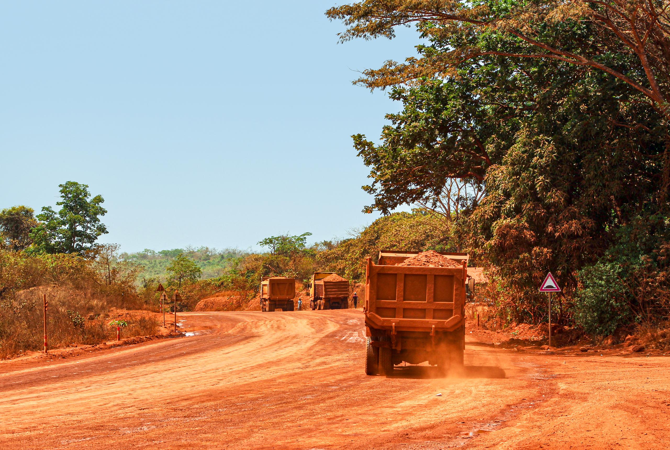 Camiones transportando bauxita por una carretera minera en Guinea. (Genevieve Campbell/UICN)