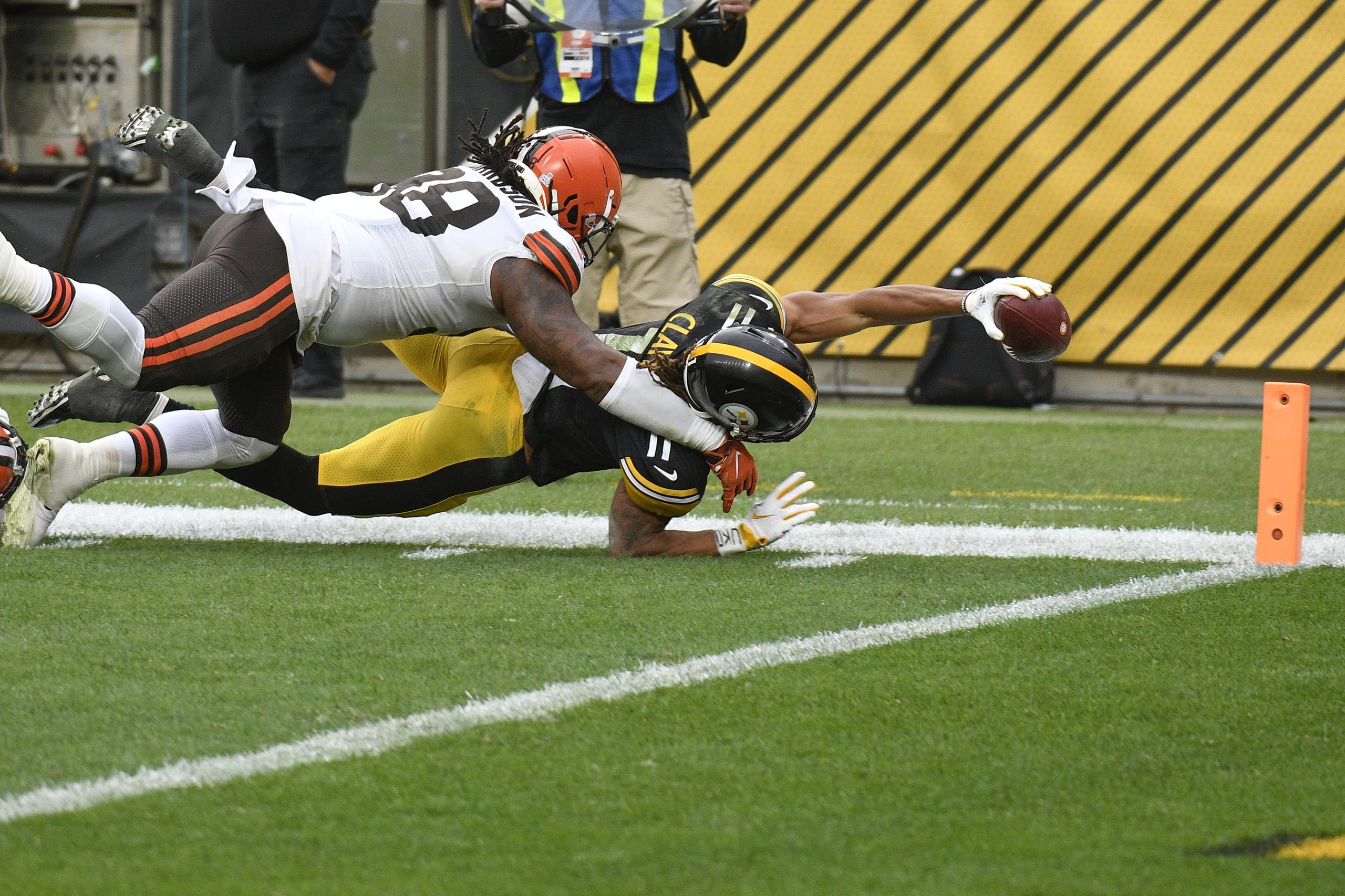 El 'wide receiver' Chase Claypool (11), de los Steelers de Pittsburgh, se estira tratando de marcar un 'touchdown' ante la gestión defensiva del 'defensive tackle' Sheldon Richardson (98), de los Browns de Cleveland.