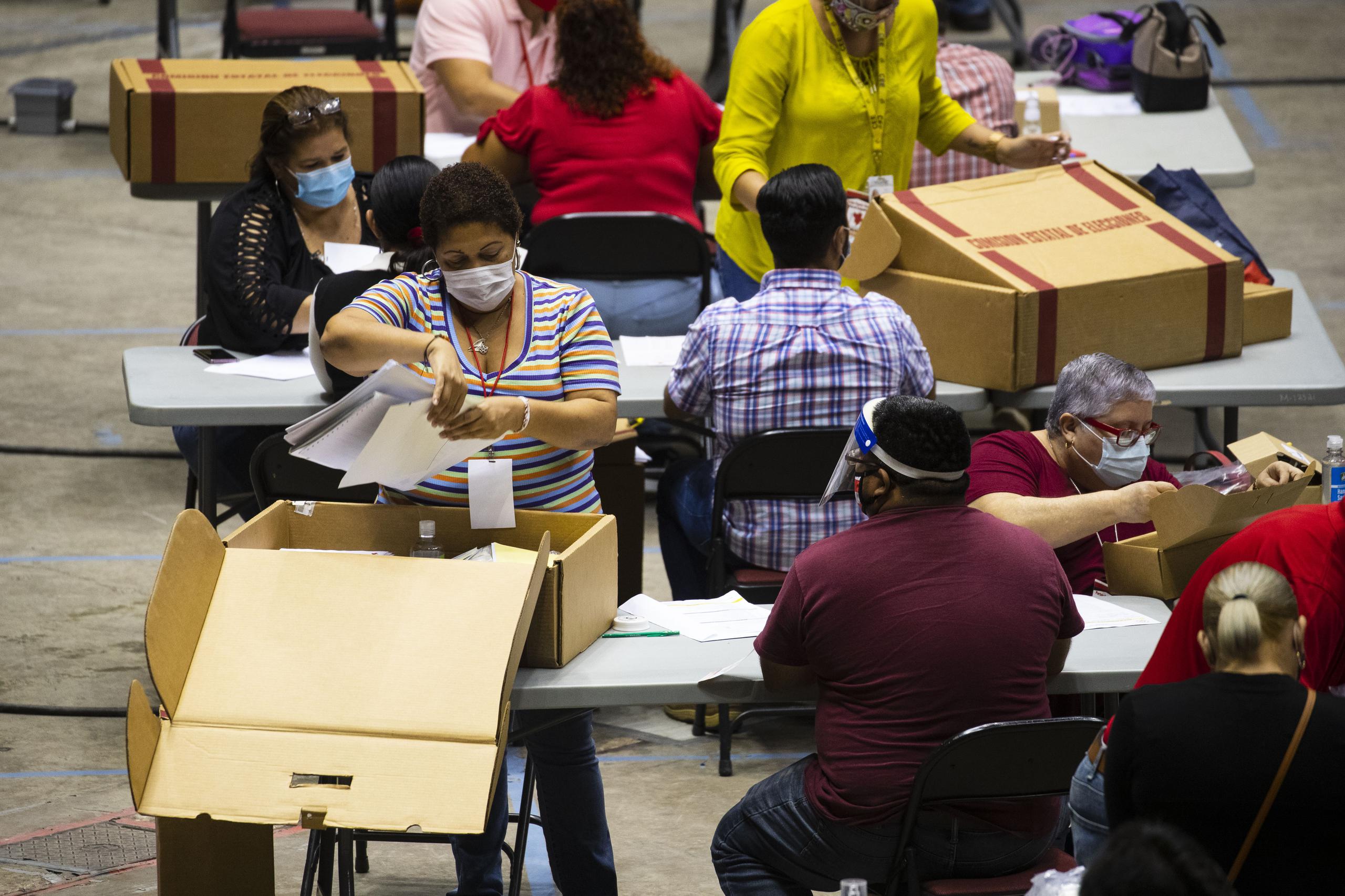 Funcionarios de colegio laboran en las mesas de contabilización de votos en el Coliseo Roberto Clemente, en Hato Rey.