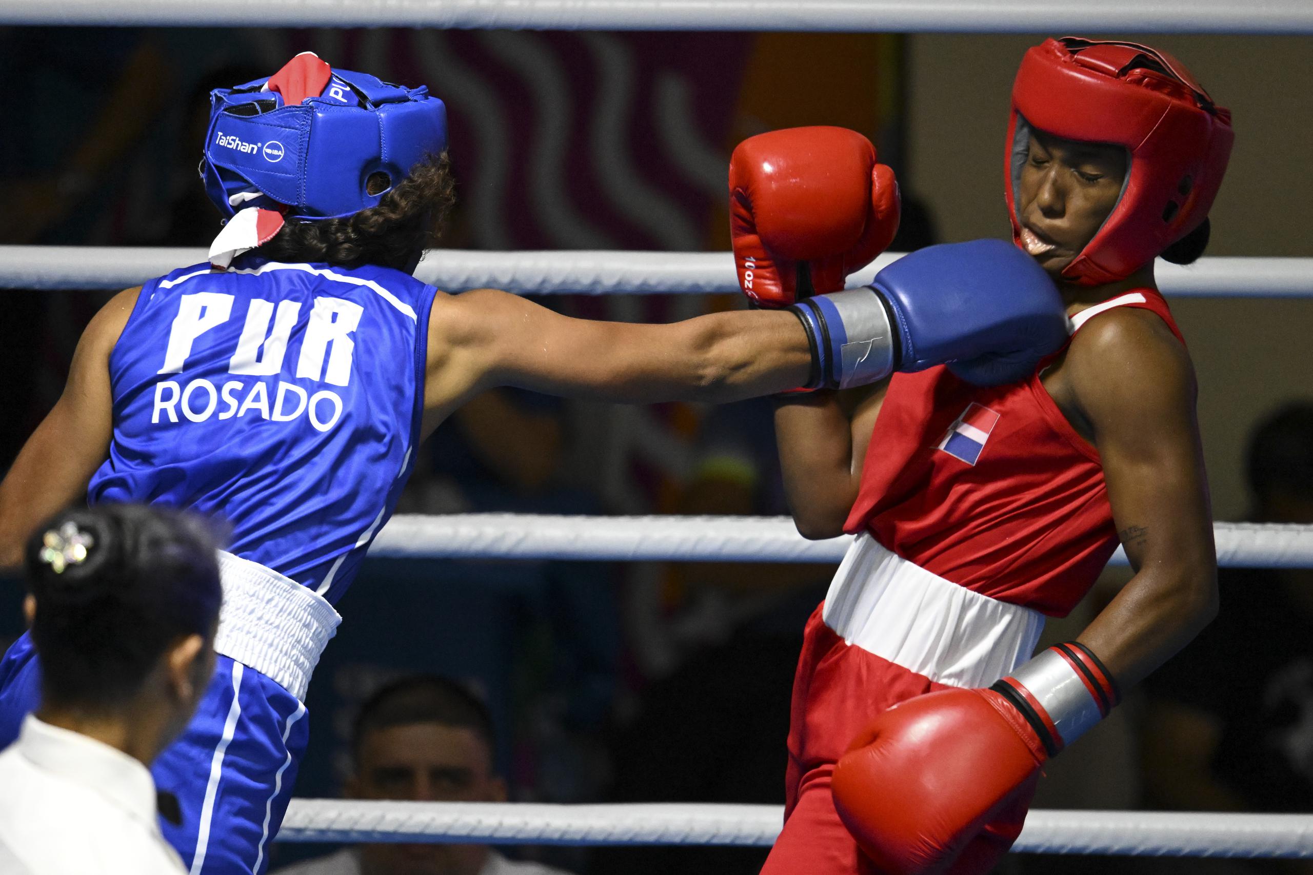 Krystal Rosado lanza una derecha sobre la dominicana Novoanny Núñez en la primera ronda del torneo de boxeo de los Juegos Centroamericanos y del Caribe en San Salvador.
