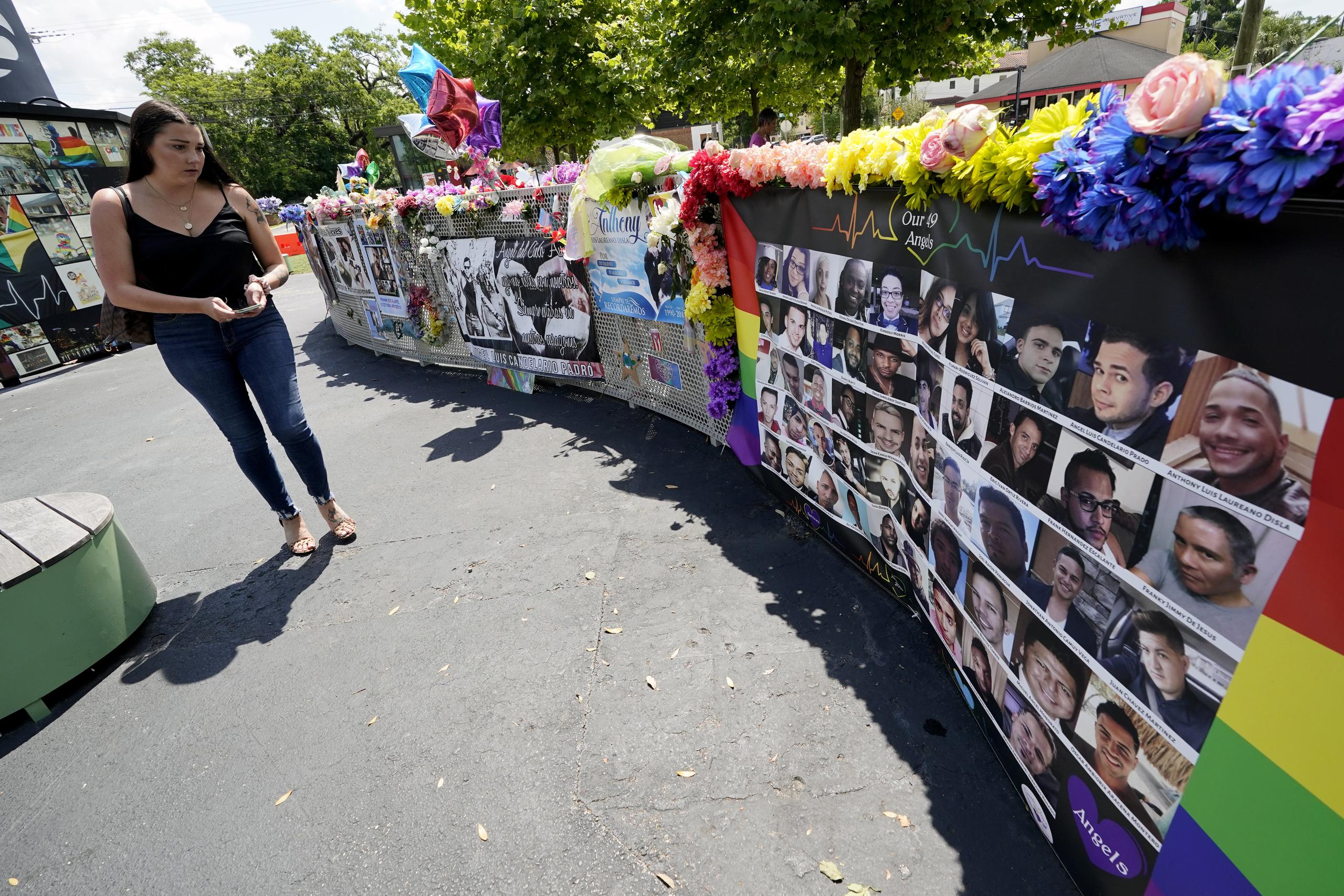 Visitante mira una exhibición con las fotos y los nombres de las 49 víctimas que fueron asesinadas el club nocturno Pulse, en Orlando, Florida.