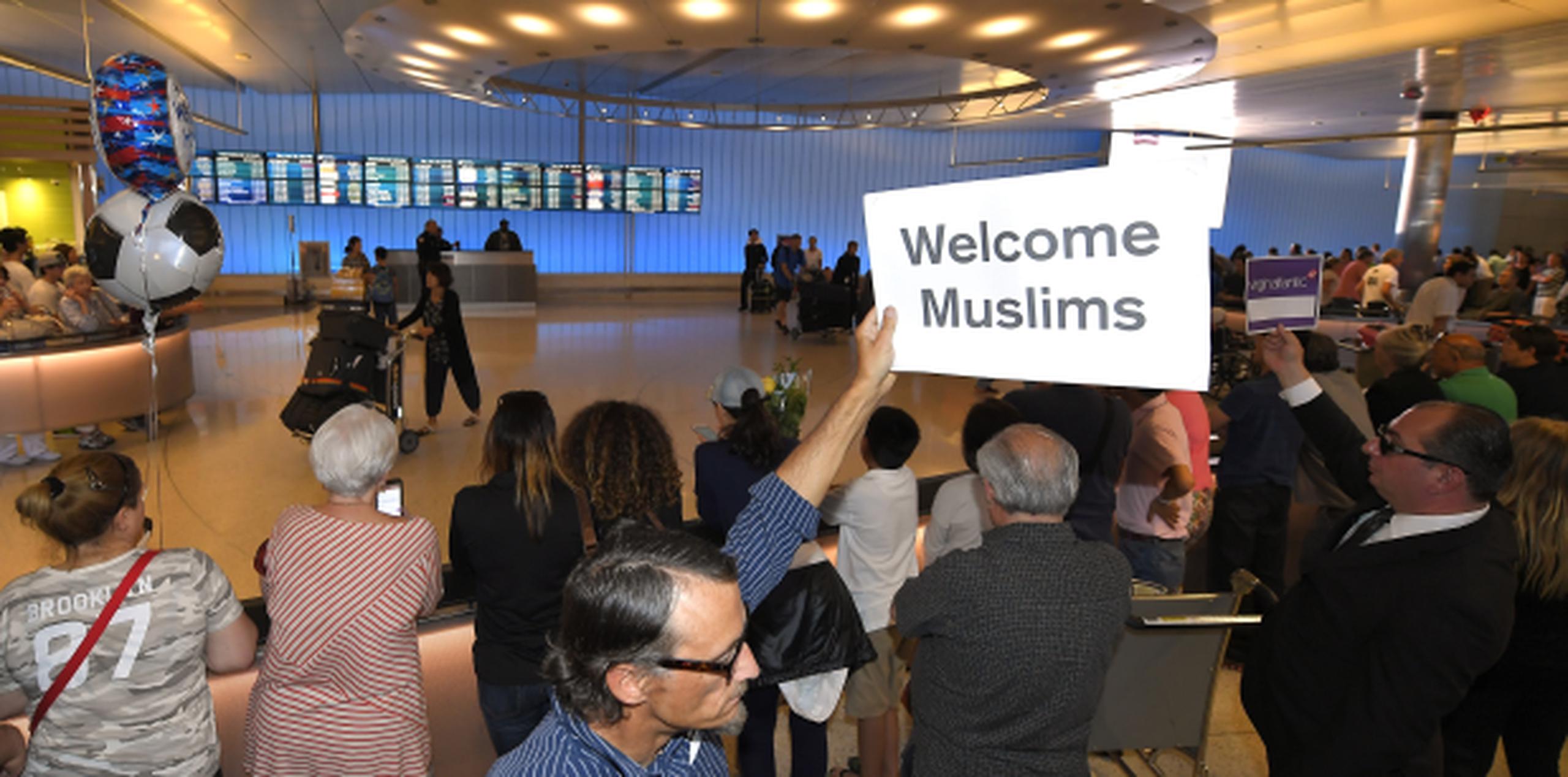 John Wider levanta un letrero que lee "bienvenidos musulmanes" en el Terminal Internacional Tom Bradley en el Aeropuerto Internacional de Los Ángeles. (AP / Mark J. Terrill)