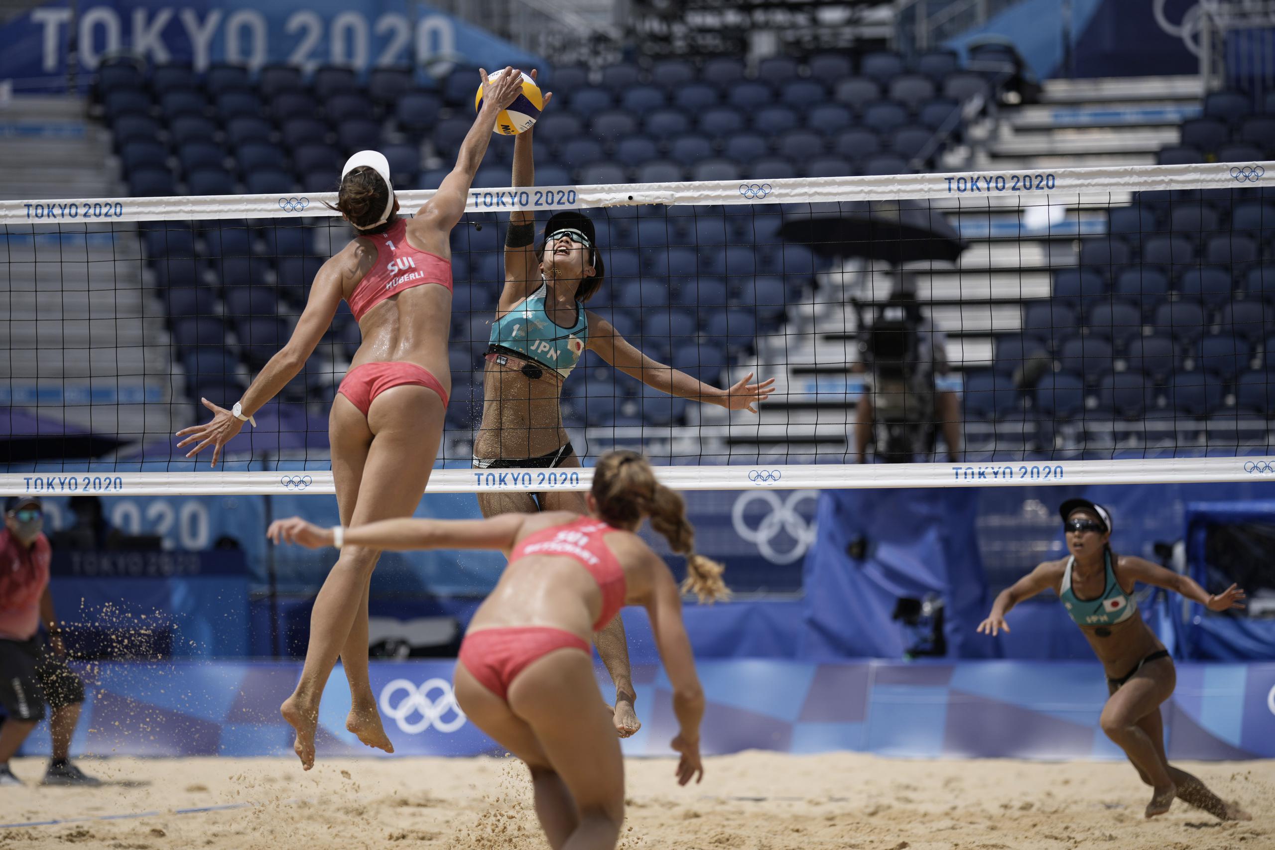 Tanja Huberli, a la izquierda, de Suiza, golpea un balón mientras Miki Ishi, de Japón, intenta bloquearlo como parte e la acción del voleibol de playa de los Juegos Olímpicos Tokio 2020.