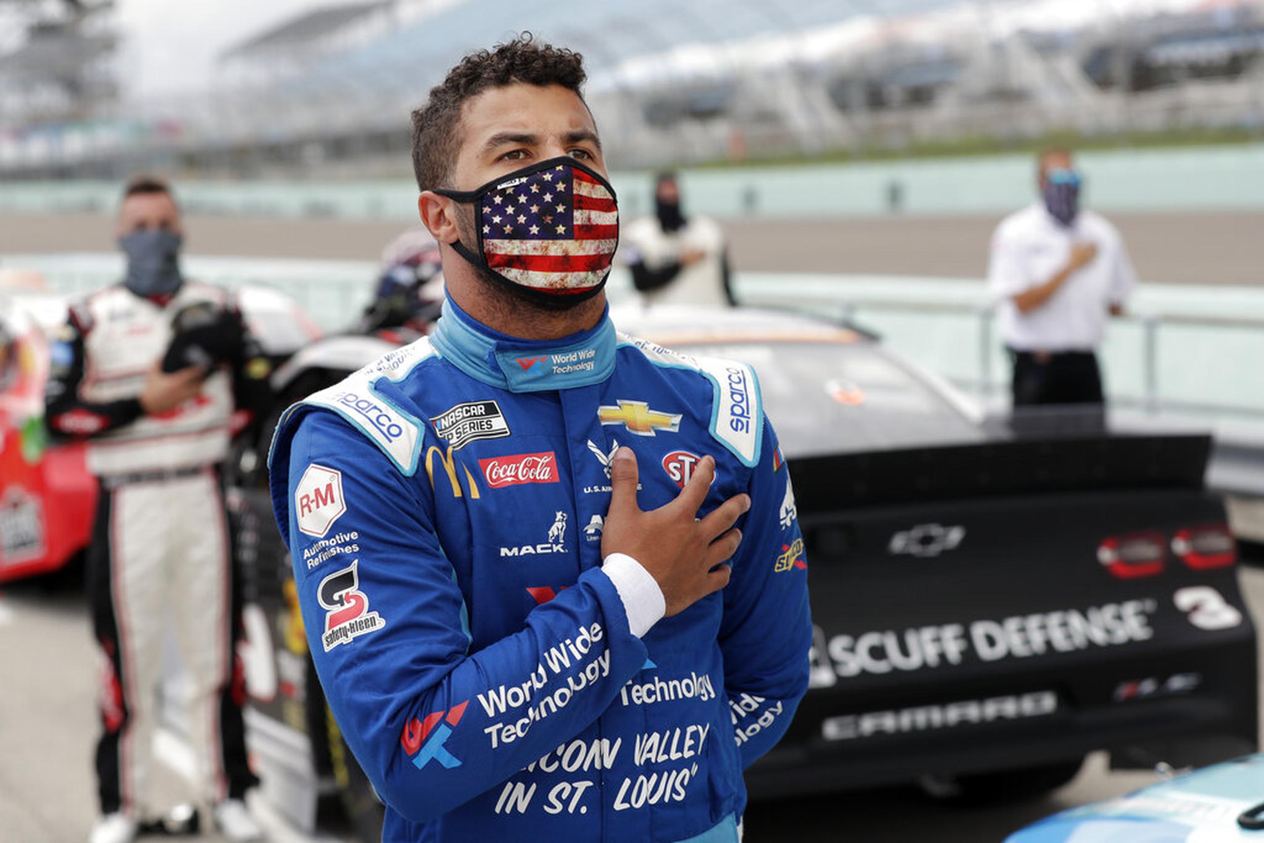 Bubba Wallace, en pie para el himno nacional antes de una carrera de la Cup Series de la NASCAR, el 14 de junio de 2020 en Homestead, Florida, EEUU. (AP Foto/Wilfredo Lee)