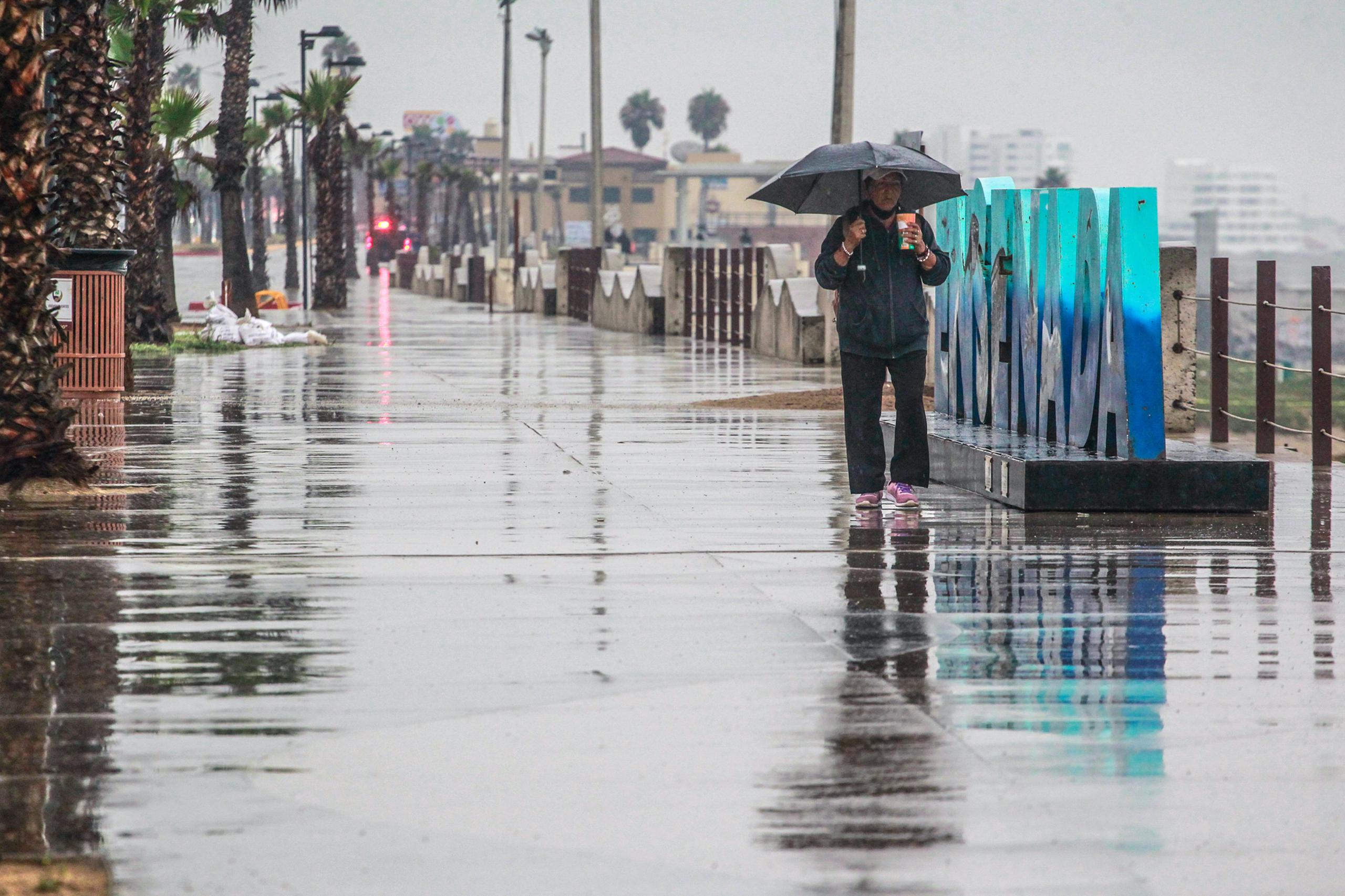 Una persona camina bajo la lluvia en el puerto de Ensenada en Baja California (México). Fotografía de archivo. EFE/Alejandro Zepeda
