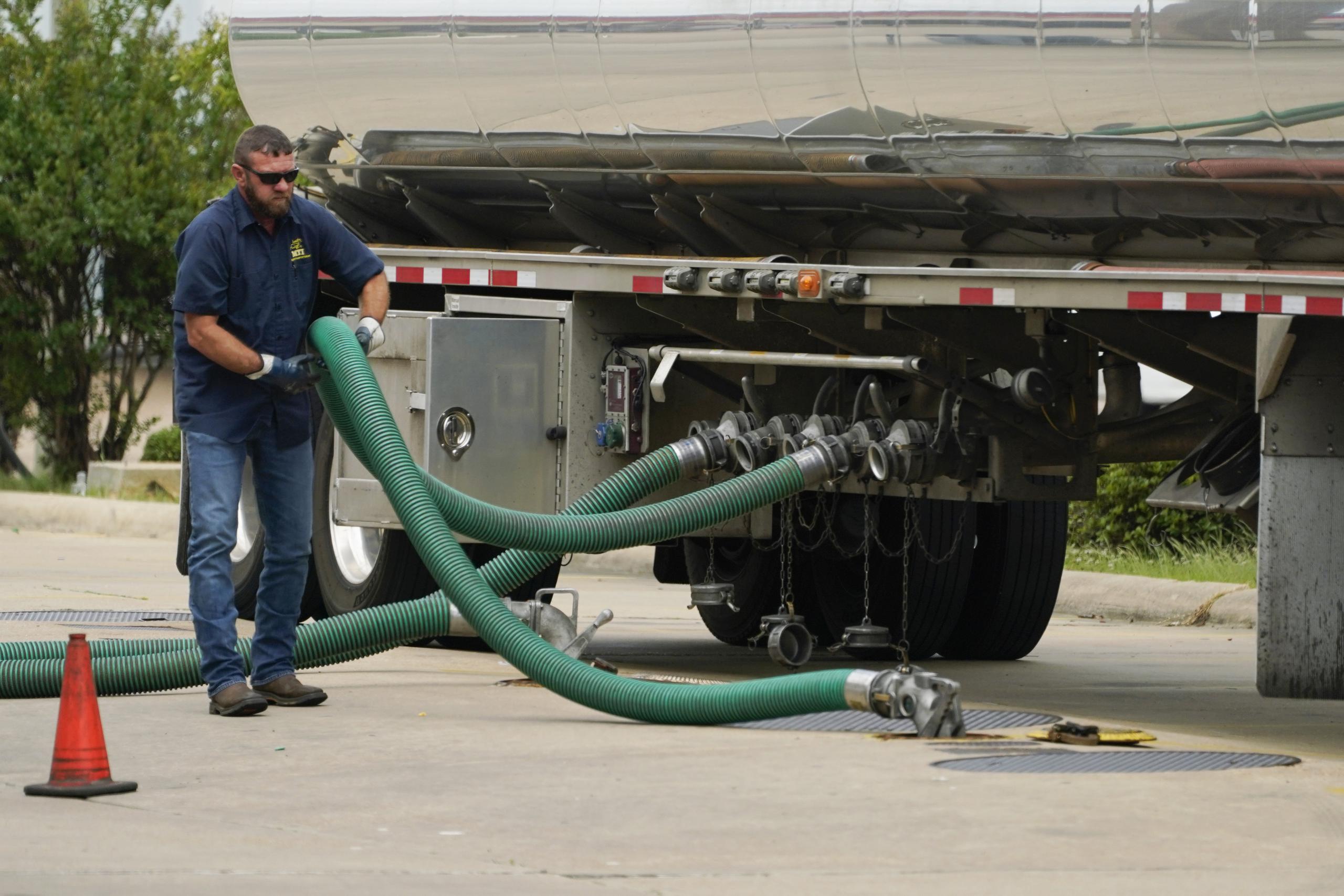 El conductor de un camión cisterna ajusta su manguera a un tanque subterráneo. (AP Foto/Rogelio V. Solis, Archivo)