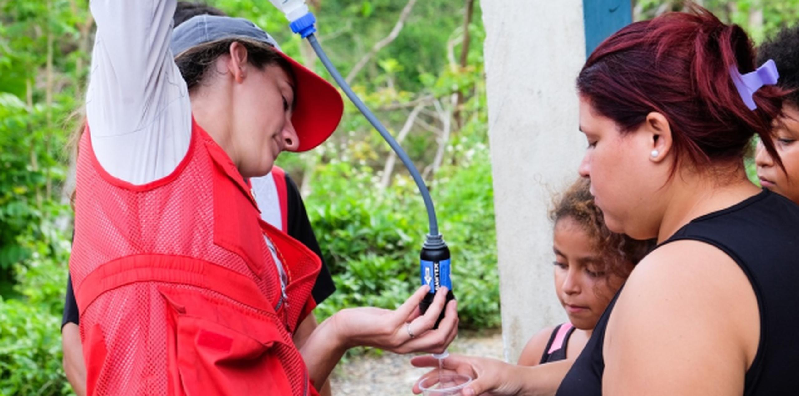 Los voluntarios muestran a las familias los beneficios de usar el sistema de filtración de agua. (Suministrada)