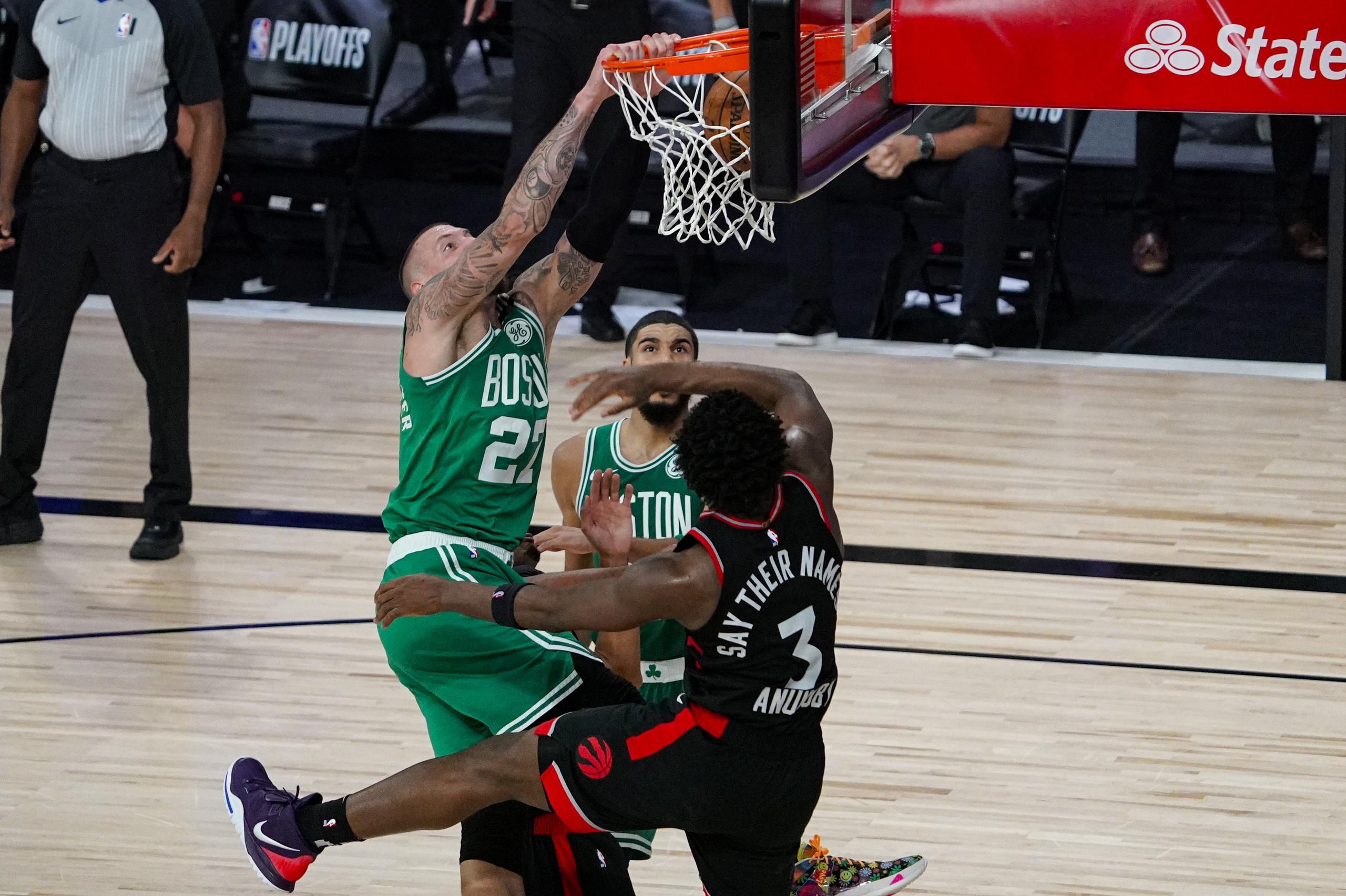 El centro de los Celtics de Boston, Daniel Theis, donquea por encima de la defensa de OG Anunoby (3), de Toronto.