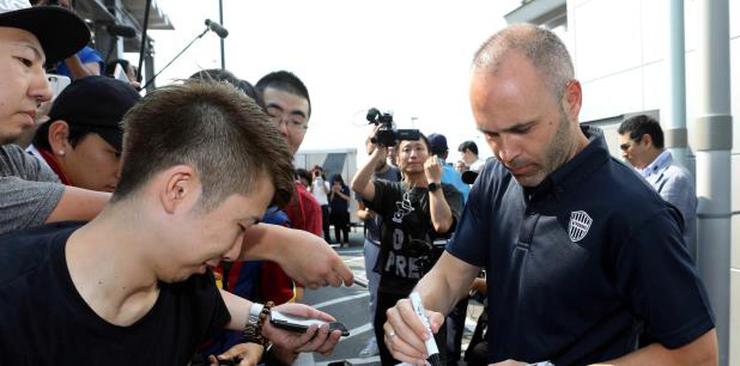 Andrés Iniesta firmó algunos autógrafos a la salida del aeropuerto. (EFE)