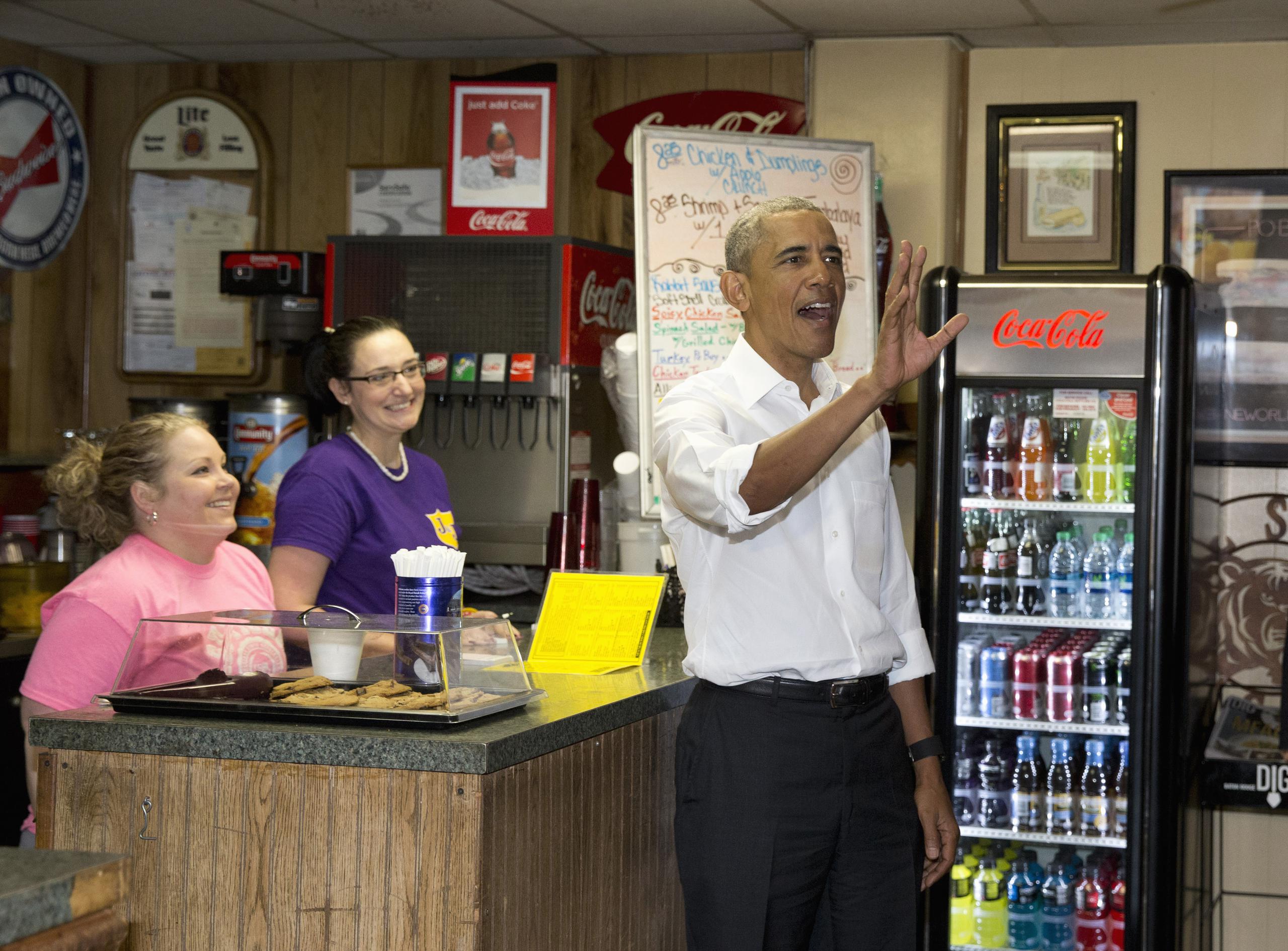 Obama saluda a unas personas mientras visita el jueves la tienda Poor Boy Lloyd's, en Baton Rouge, Louisiana.(AP)