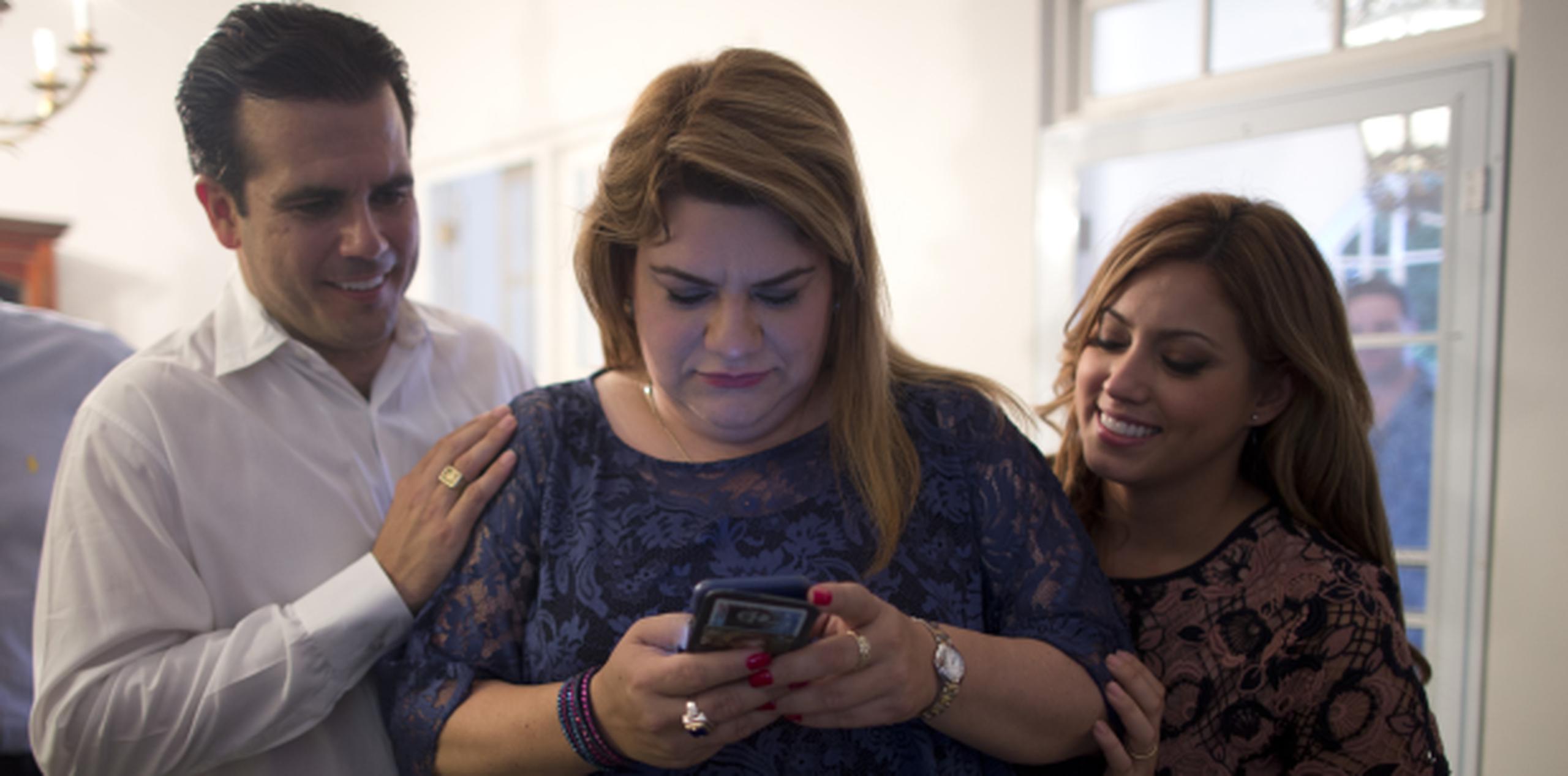 Rosselló y su esposa Beatriz observan a González mientras examina su teléfono. (teresa.canino@gfrmedia.com)