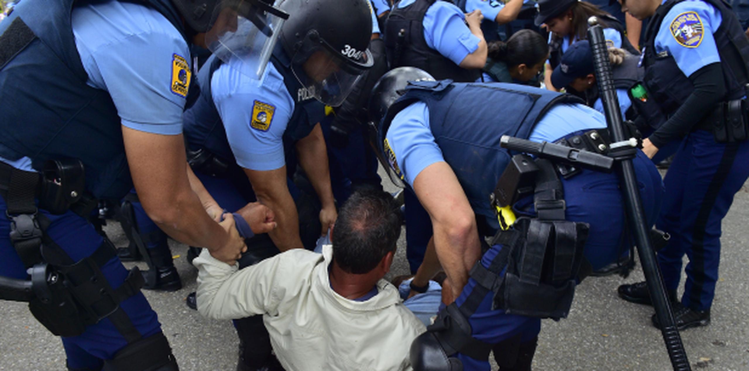 Agentes de la Unidad de Operaciones Tácticas en medio del arresto a un manifestante esta mañana en Peñuelas. (tony.zayas@gfrmedia.com)