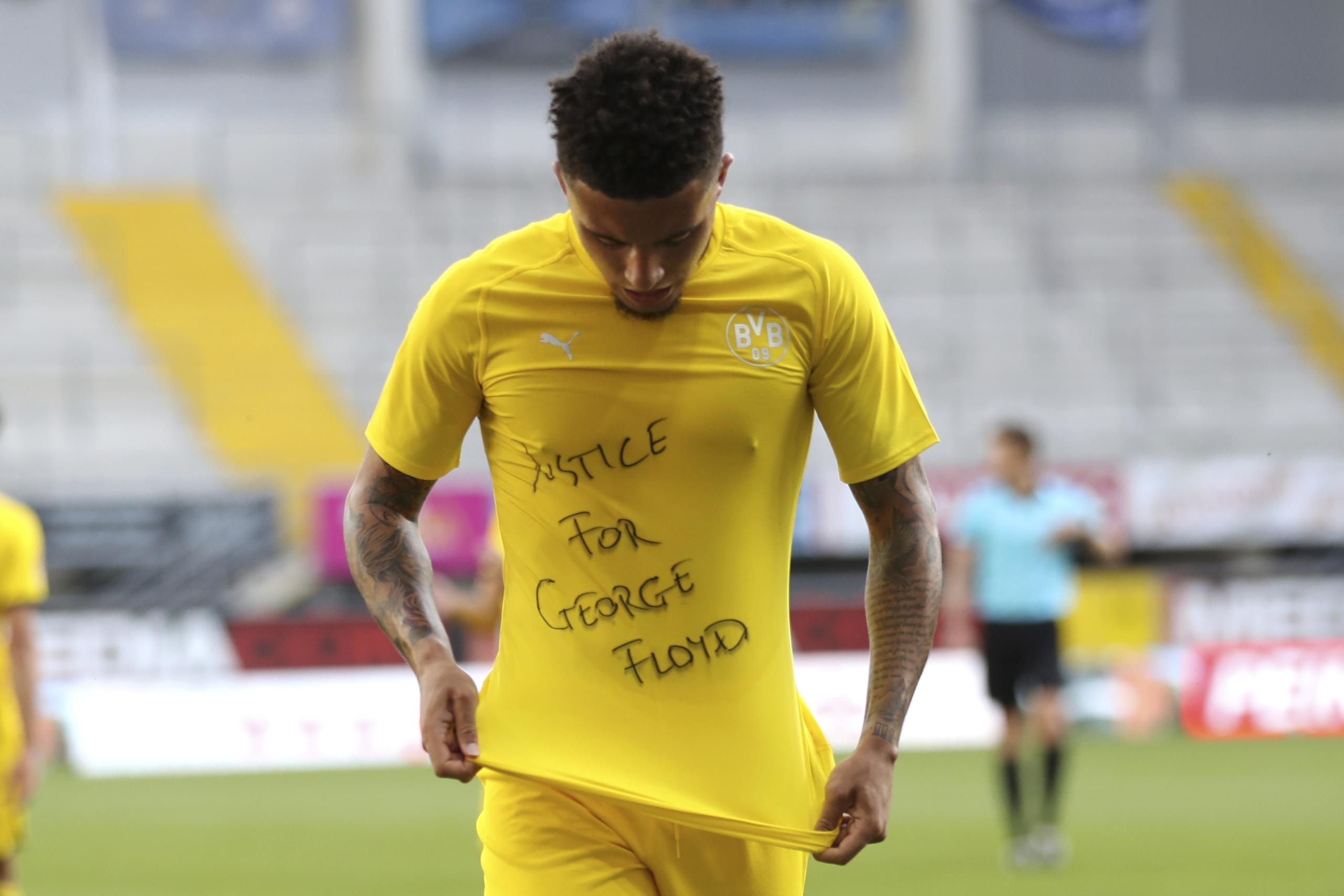 Esta foto del 31 de mayo del 2020  muestra a Jadon Sancho, del Borussia Dortmund, celebrando su gol mientras muestra una playera con la frase "Jusitica para George Floyd".