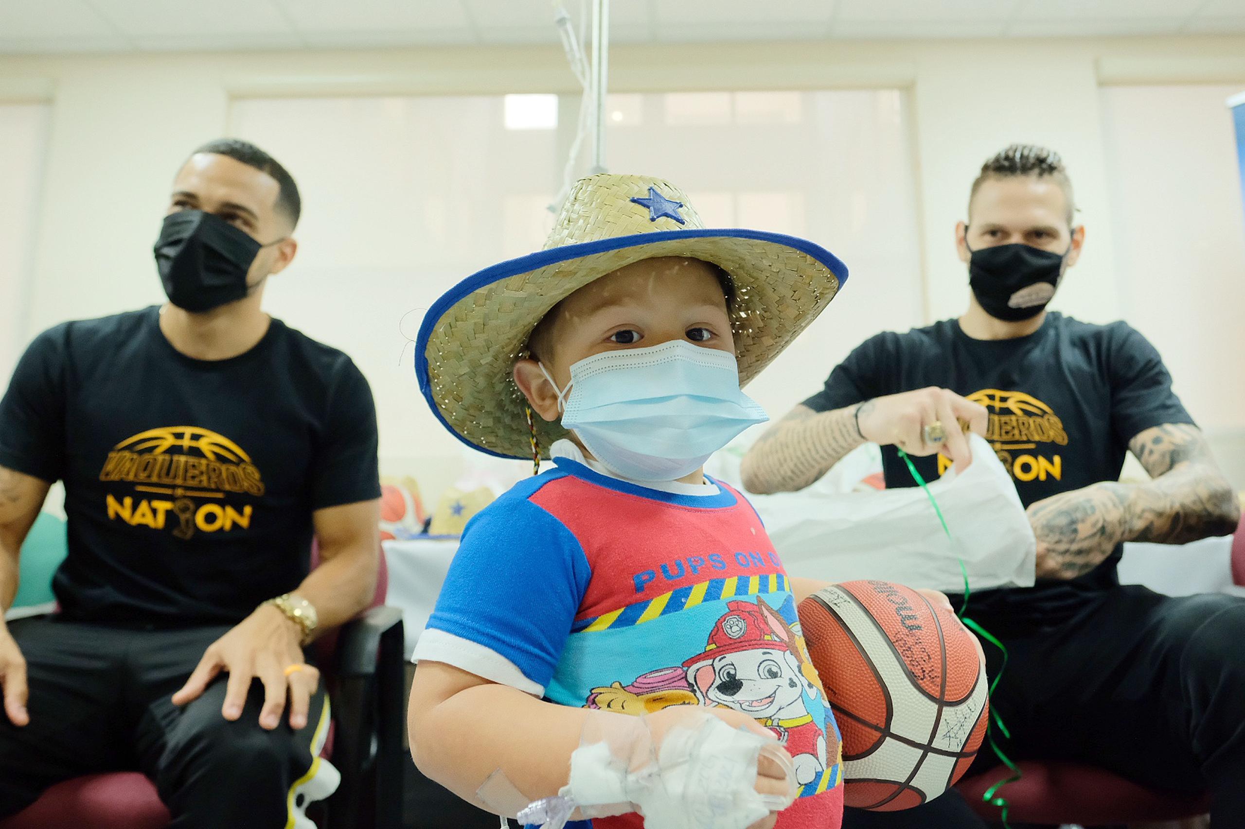 Ángel Rodríguez y Benito Santiago Jr. comparten con uno de los niños en el Hospital Bayamón Medical Center.