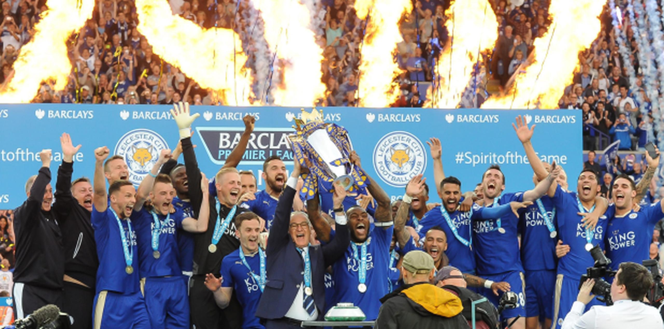 El técnico Claudio Ranieri levanta el trofeo de campeones junto al capitán del Leicester City, Wes Morgan, al tiempo que estallaban las celebraciones en el estadio King Power. (EFE/EPA/SIMON KIMBER)