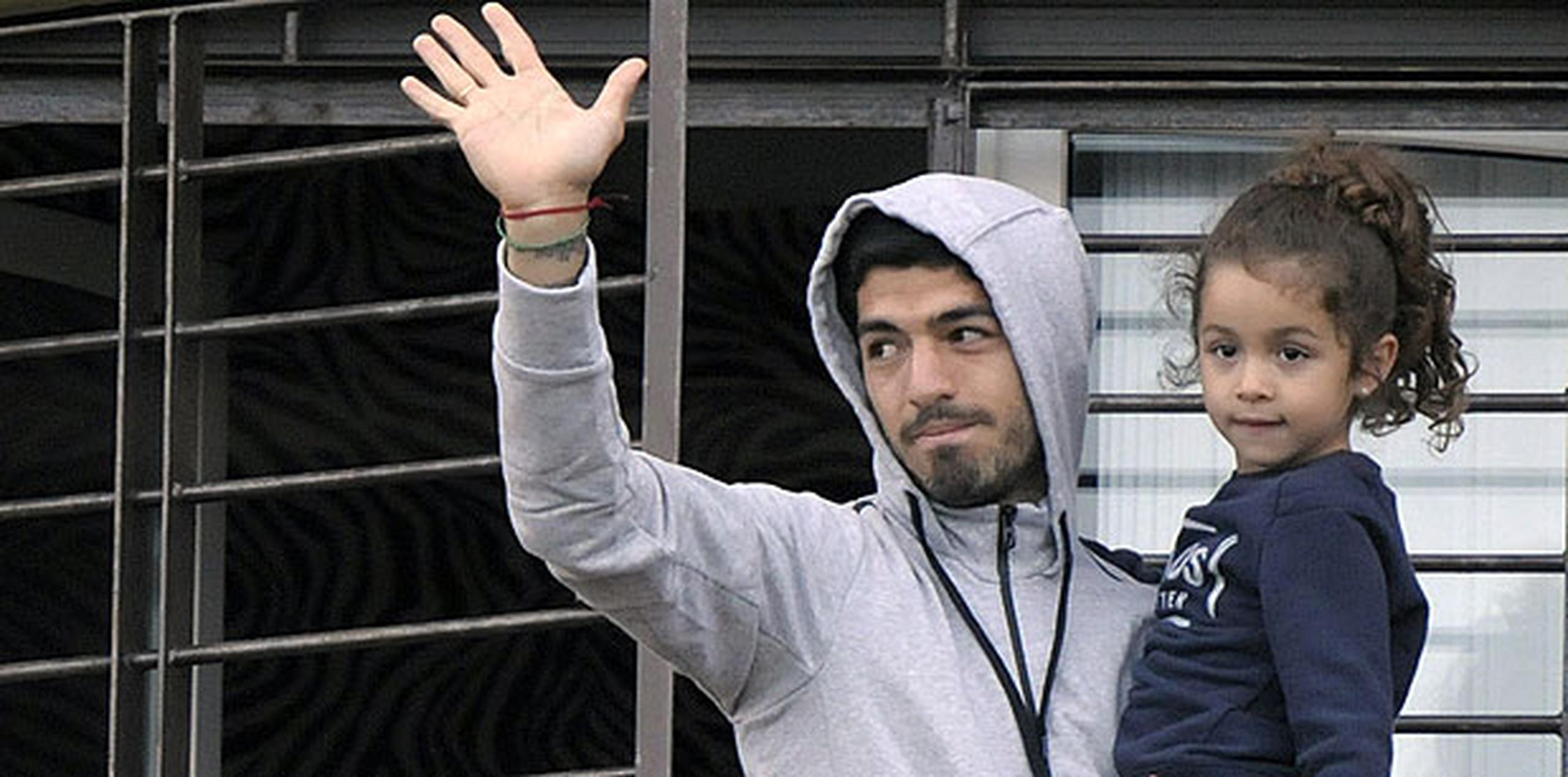 Desde su balcón en Montevideo, han sido varias las veces que el jugador, en compañía de sus hijos y esposa, ha salido para saludar a los fanáticos que lo apoyan en la calle. (AP)