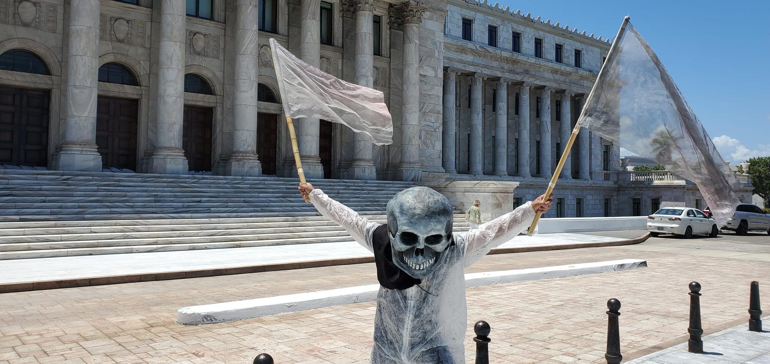 Una hombre personifica una cadavera durante la manifestación en contra del secretario del DRNA, Rafael Machargo, en el Capitolio.