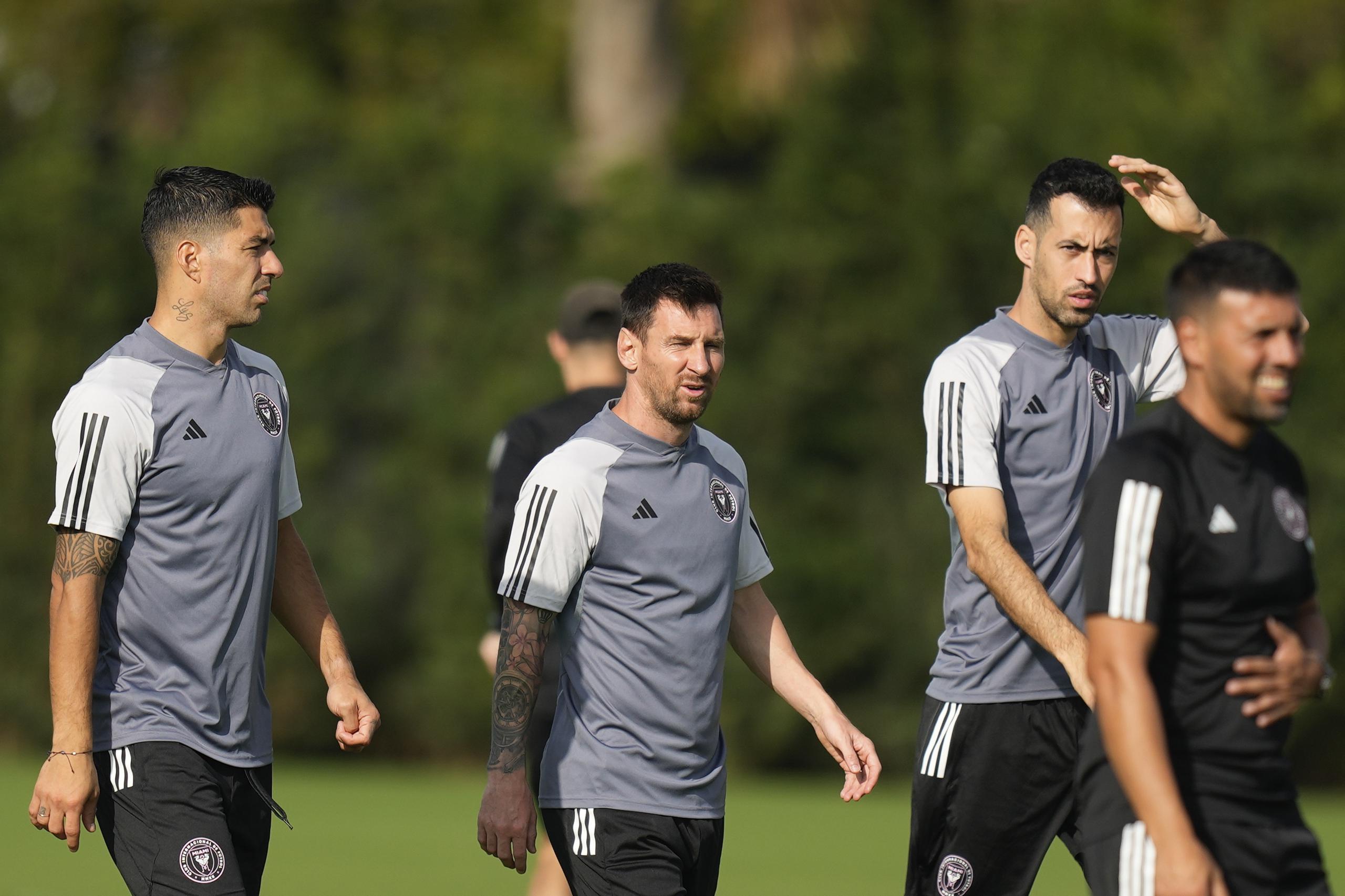 Luis Suárez, a la izquierda, camina con el delantero Lionel Messi, centro, y el defensa Sergio Busquets, segundo a la derecha, durante una sesión de entrenamiento de fútbol de la MLS,