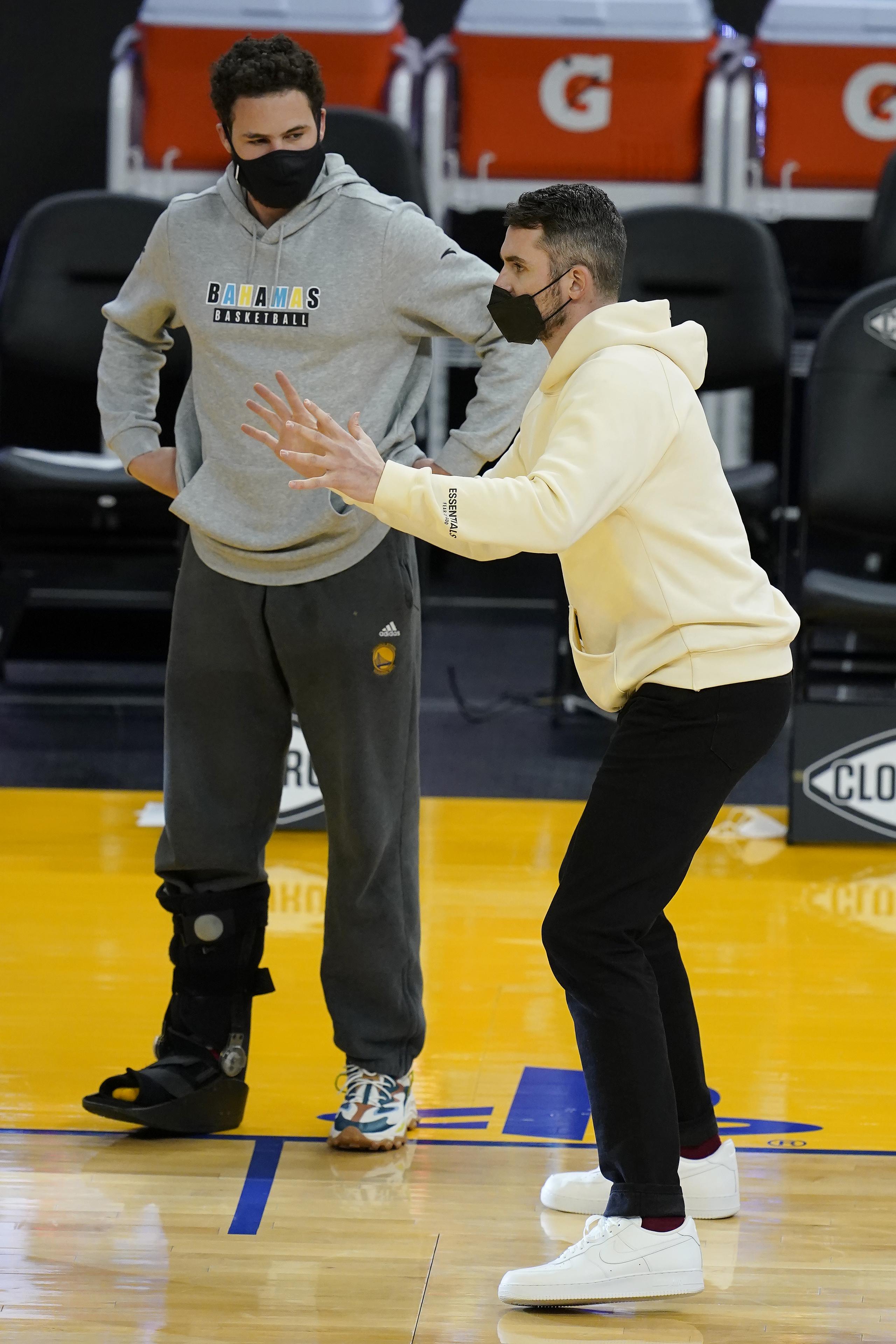 El delantero de los Warriors de Golden State, Klay Thompson, a la izquierda junto a Kevin Love, ya puede caminar sin usar la bota protectora. Este trabaja en una lesión del tendón de Aquiles.