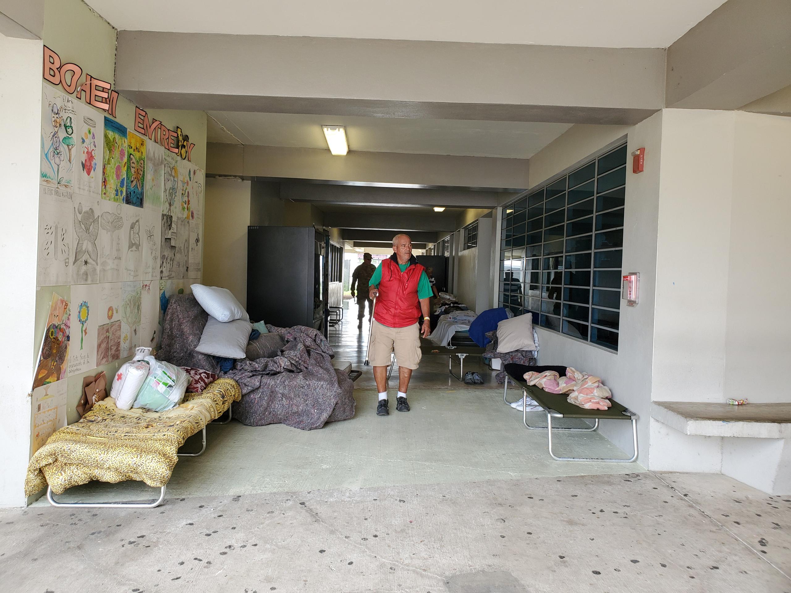Refugiados han colocados sus catres en los pasillos de la escuela vocacional Bernardino Cordero Bernard.