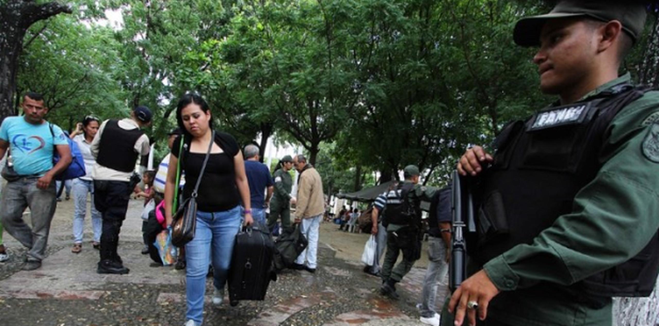 Bajo vigilancia de policías de Venezuela, colombianos regresan a su país tras el cierre de la frontera y la deportación de indocumentados. (AFP)