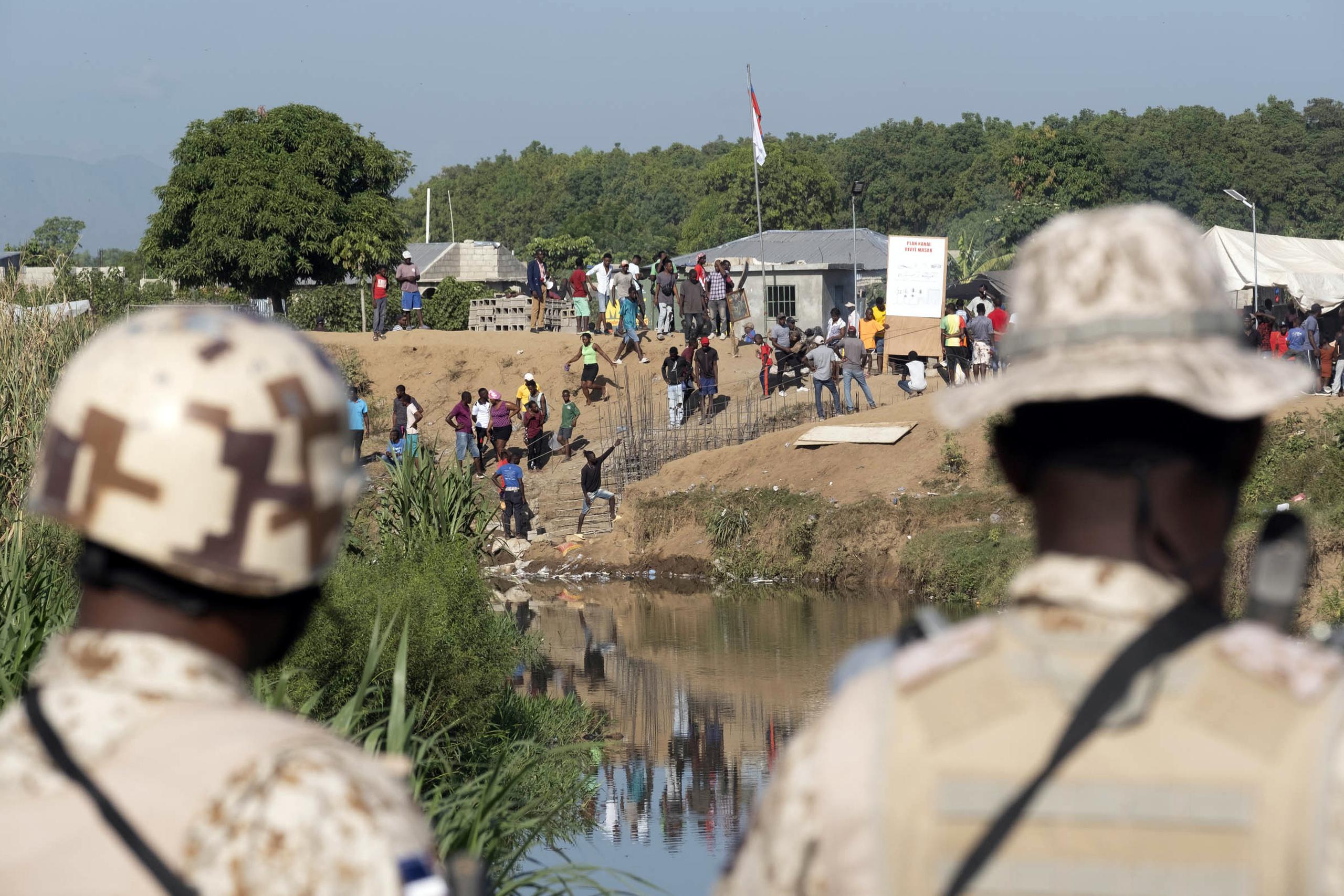 Soldados dominicanos en la orilla del río Masacre observan a trabajadores de construcción en el lado haitiano, desde Dajabón, República Dominicana.