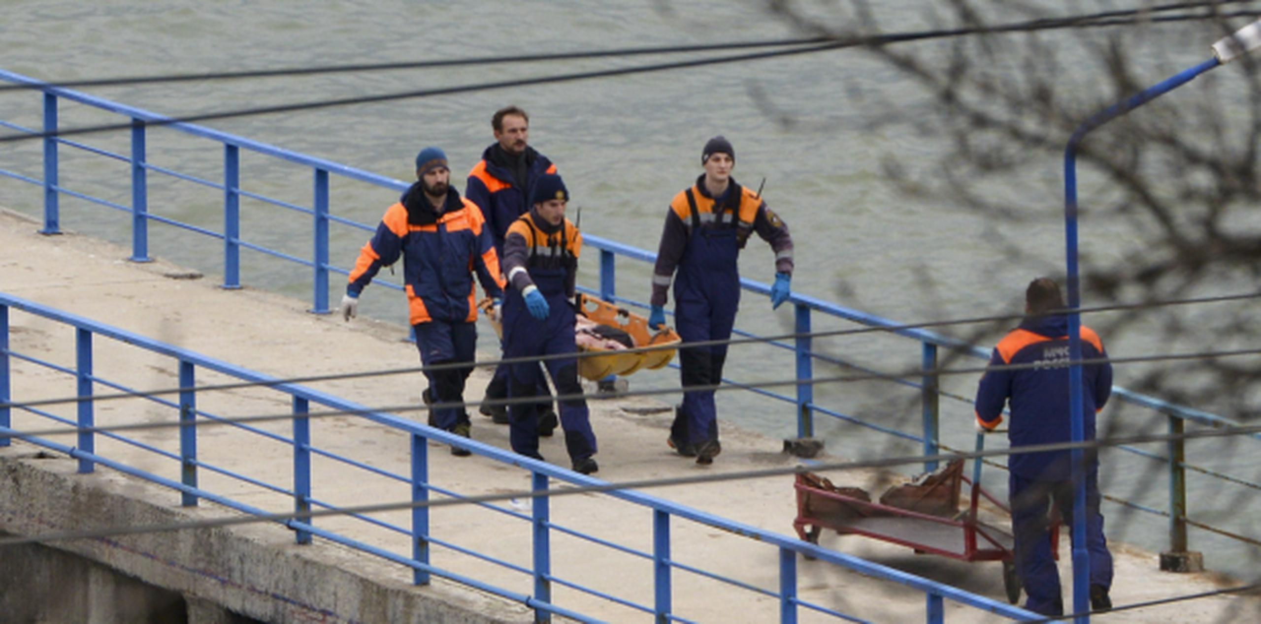 Rescatistas cargan con una de las víctimas de la tragedia. (Prensa Asociada)