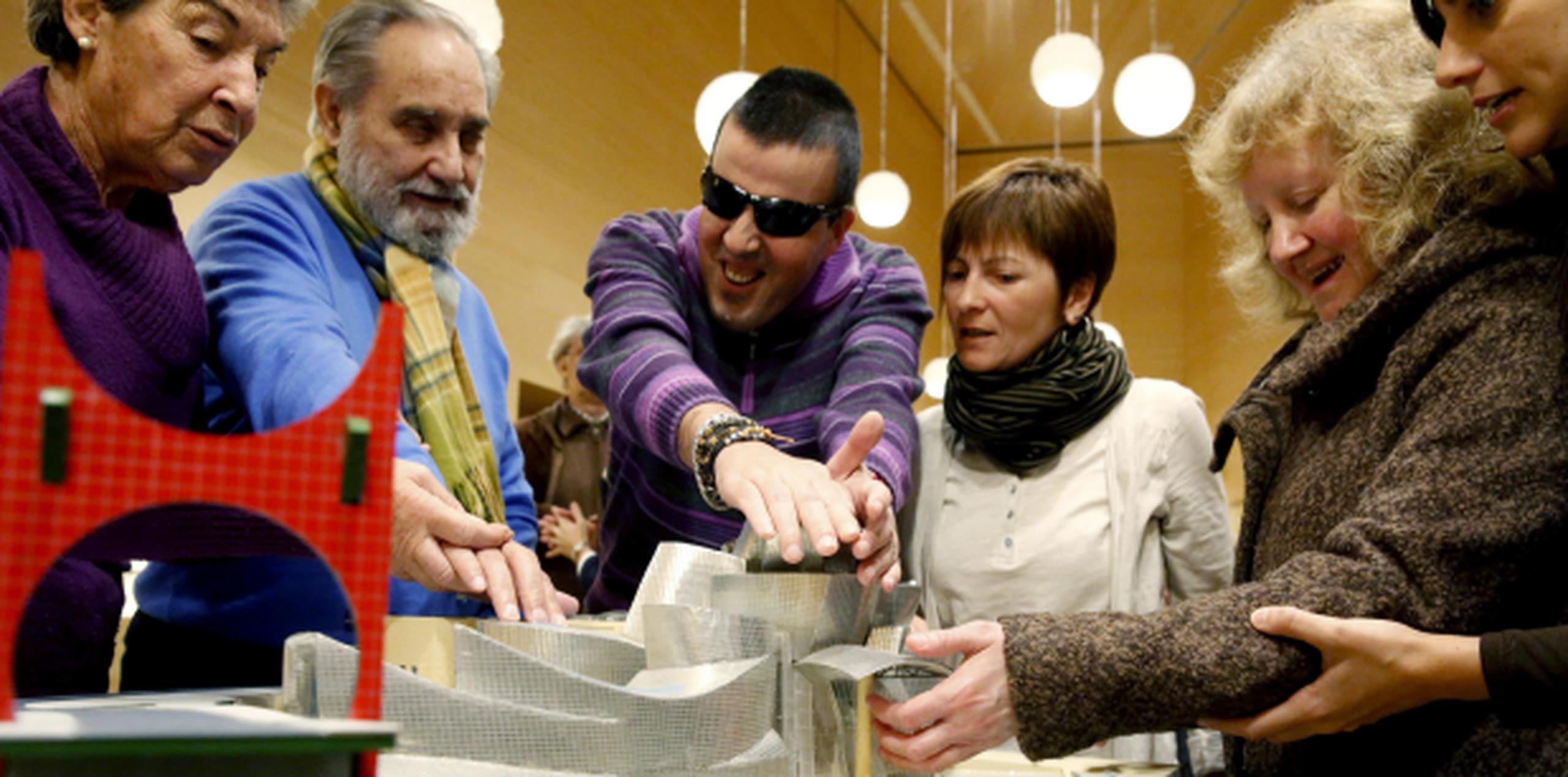 Ciegos tocan una de las nuevas maquetas del Museo Guggenheim de Bilbao, donde hoy se han dado a conocer los nuevos dispositivos para personas con discapacidades. (EFE)