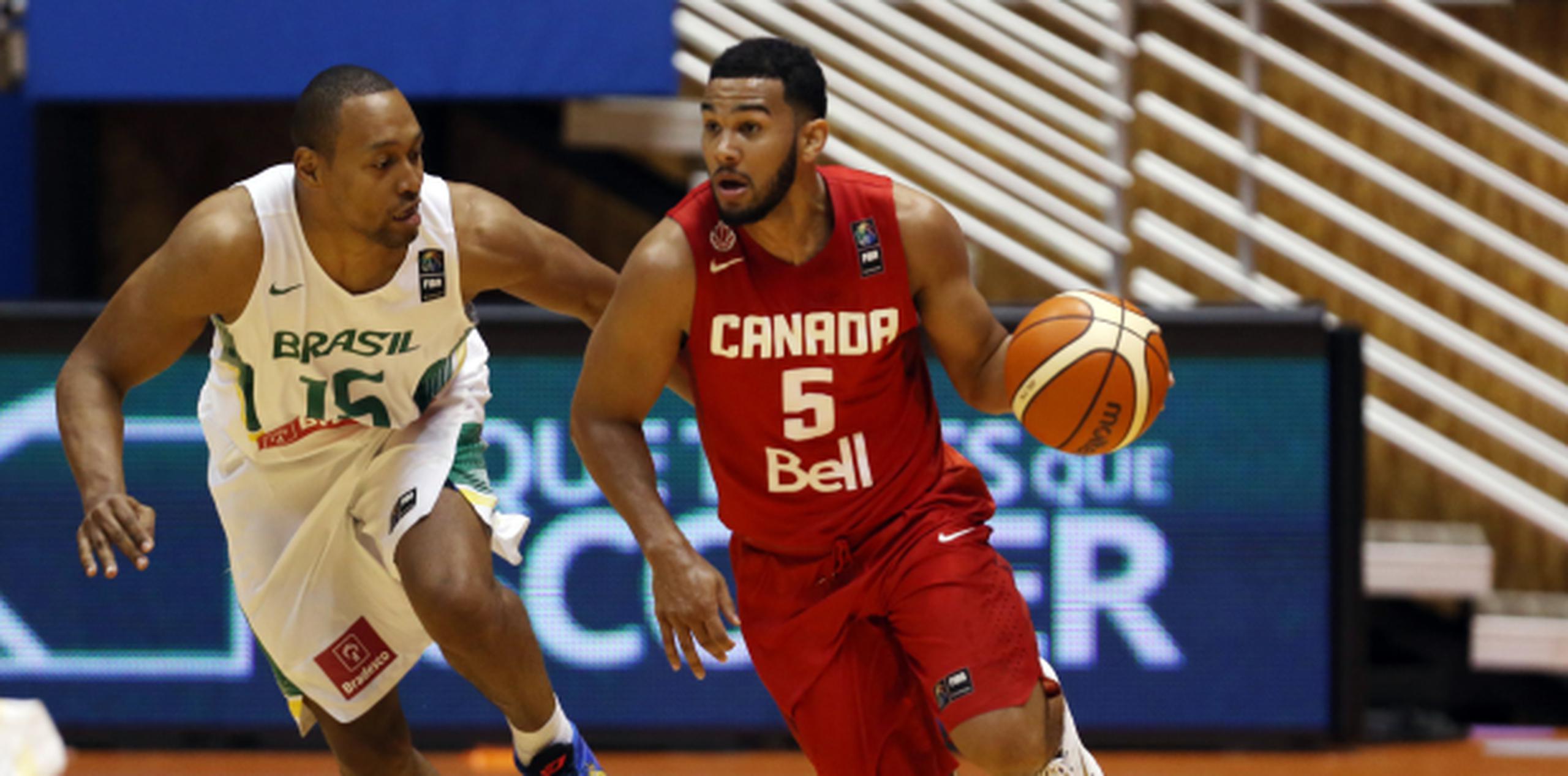 El canadiense Cory Joseph ante la defensa de Marcus Toledo, de Brasil, podrían medirse en el Preolímpico de baloncesto que inicia mañana. (juan.martinez@gfrmedia.com)