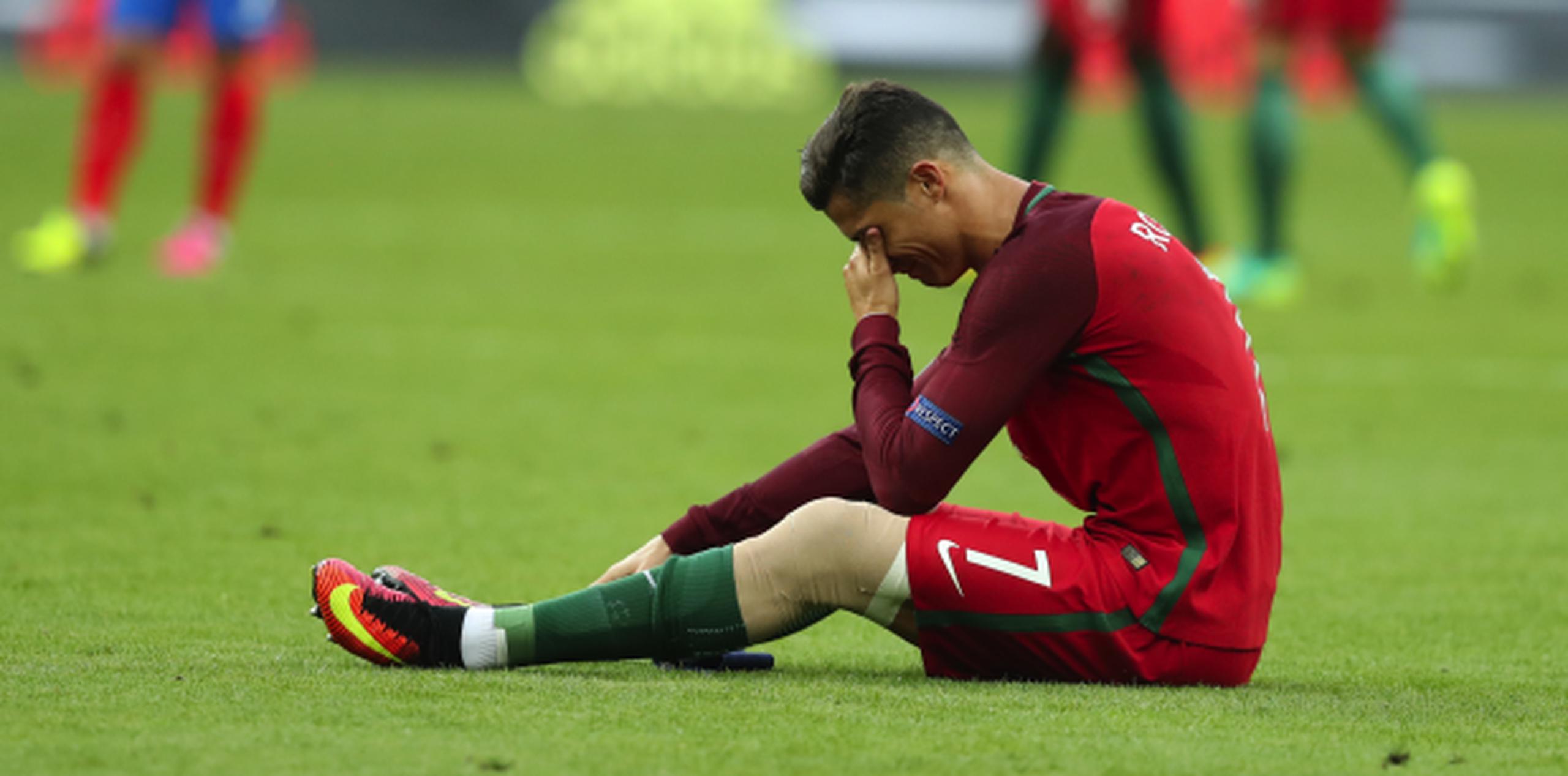 Cristiano Ronaldo espera por la camilla sobre el campo del Stade de France luego de sufrir una lesión que le impidió continuar jugando la final. (AP/Thanassis Stavrakis)