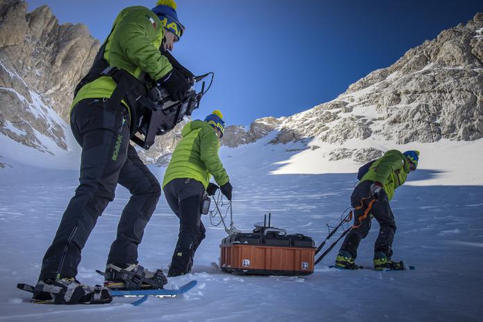Científicos transportan un escáner de hielo en las laderas del monte. (Riccardo Selvatico/CNR y Universidad Ca Foscari vía AP)