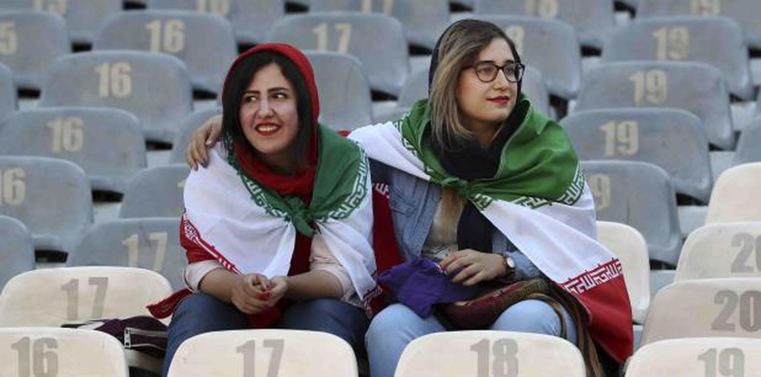 Dos mujeres observan el partido del jueves en el que la selección de Irán goleó 14-0 a Camboya. (AP)